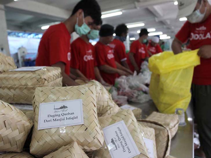 Petugas mengemas potongan daging hewan kurban menggunakan besek di Masjid Istiqal,  Jakarta, Minggu (11/8)