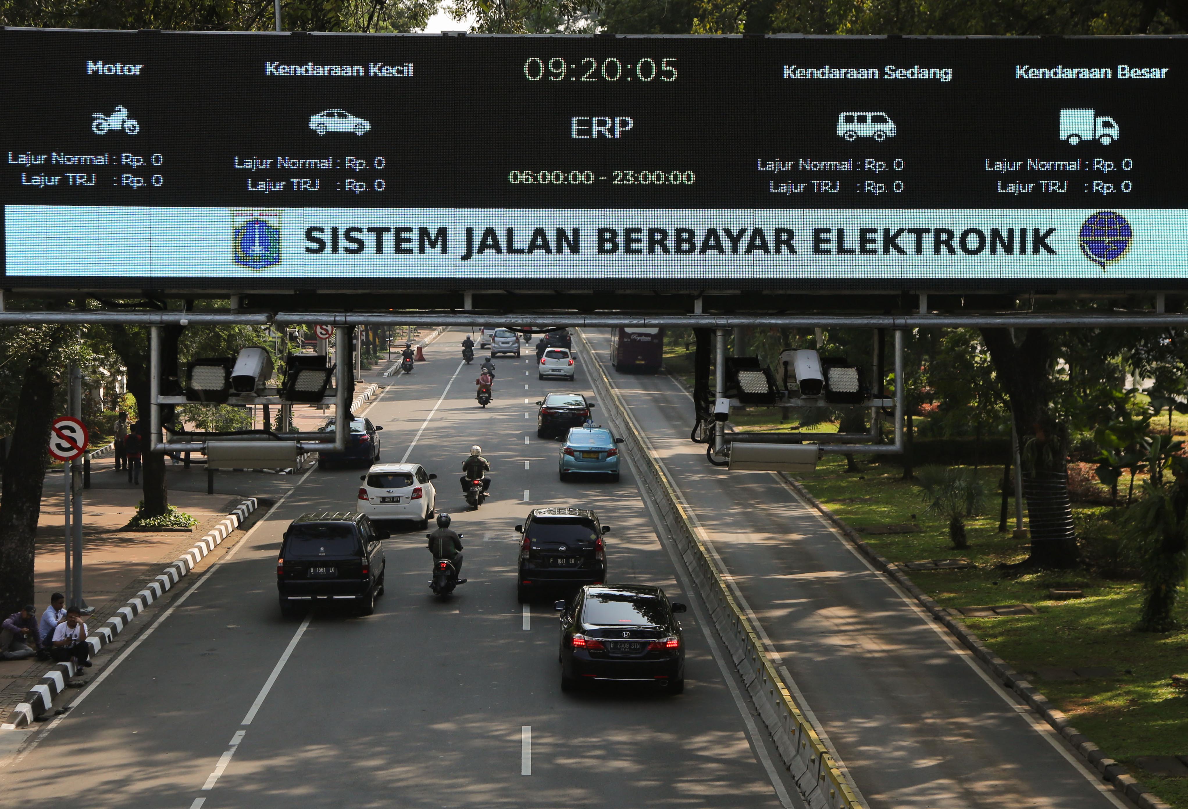 Pengendara melintasi alat teknologi sistem jalan berbayar elektronik (ERP) di Jalan Merdeka Barat, Jakarta.