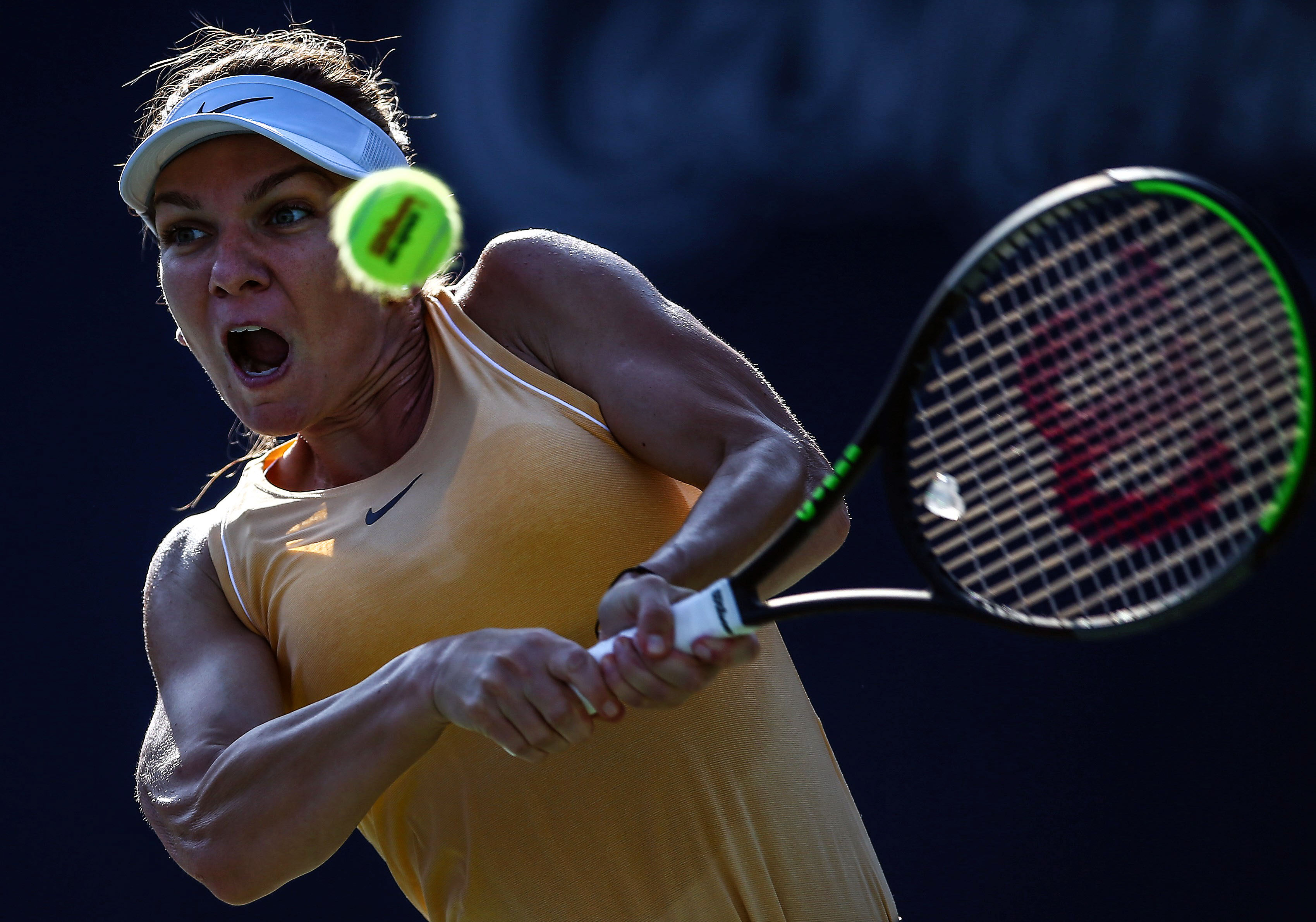 Simona Halep dari Rumania mengambilkan bola ke arah lawannya Svetlana Kuznetsova dari Rusia. 