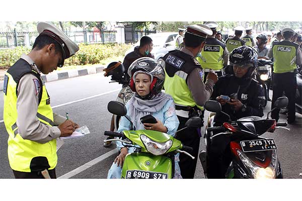 Ilustrasi -- Polisi menilang pengendara motor saat menggelar Operasi Zebra di kawasan Tanjung Barat, Jakarta, Minggu (4/11). 