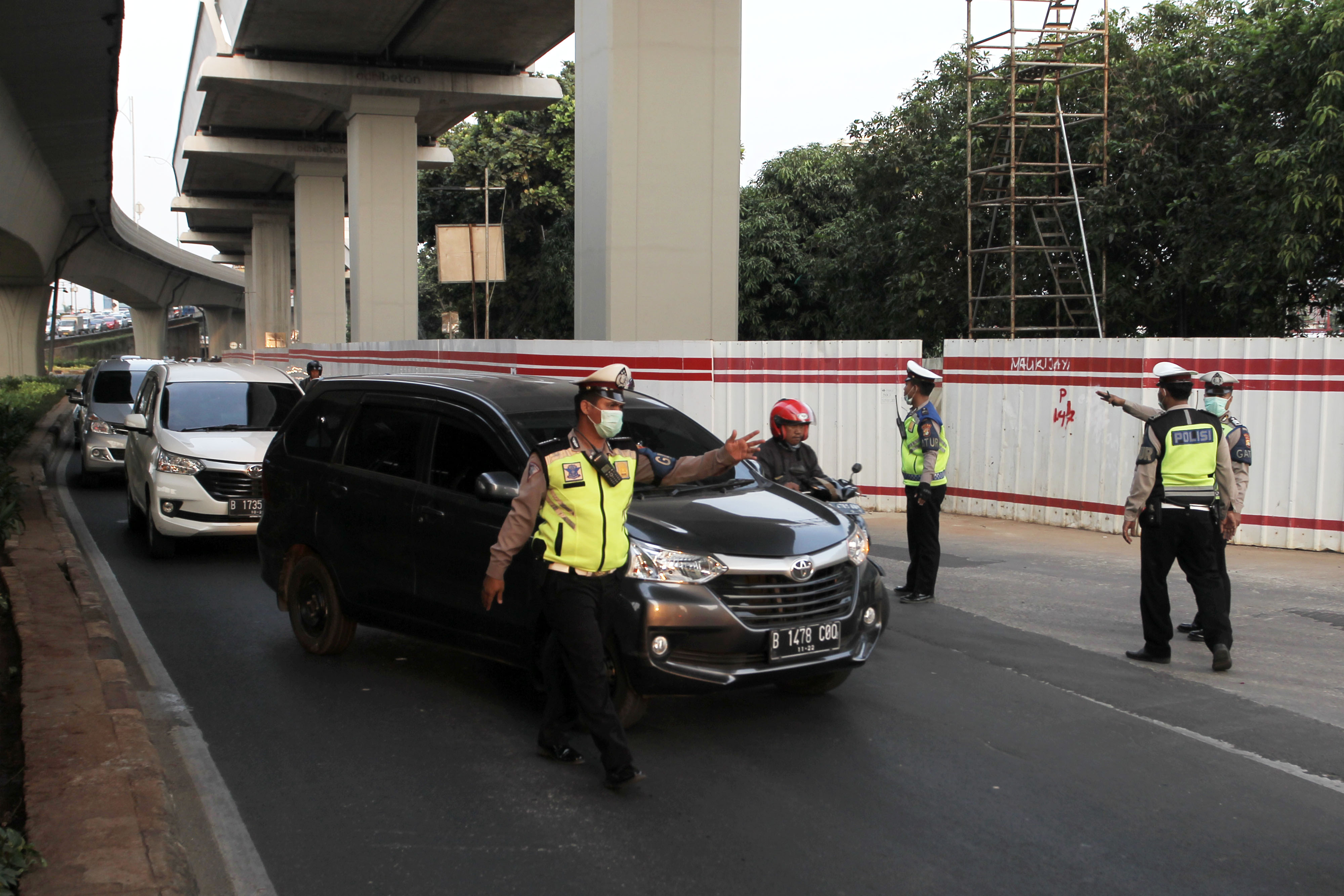 Petugas Kepolisian melakukan penindakan terhadap kendaraan roda empat yang melanggar aturan ganjil-genap di Jalan MT. Haryono, Jakarta