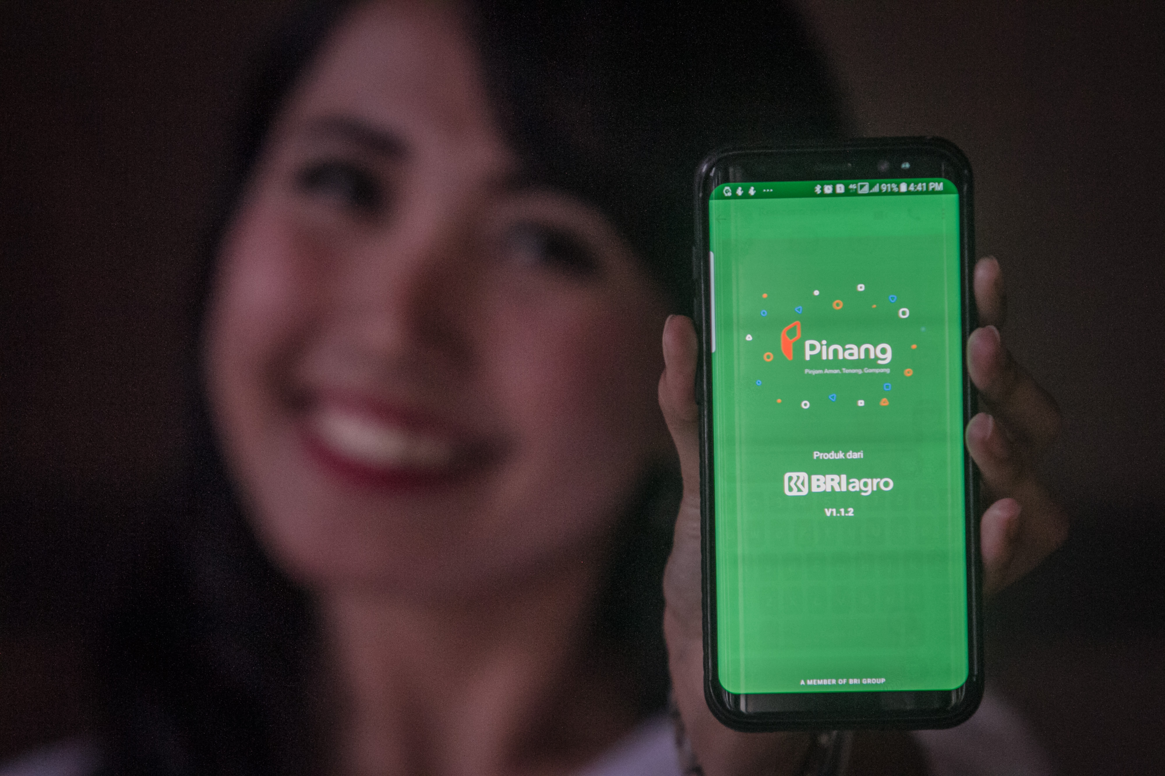 Pegawai Bank Rakyat Indonesia (BRI) Agro menunjukkan aplikasi pinjaman berplatform online 'Pinang