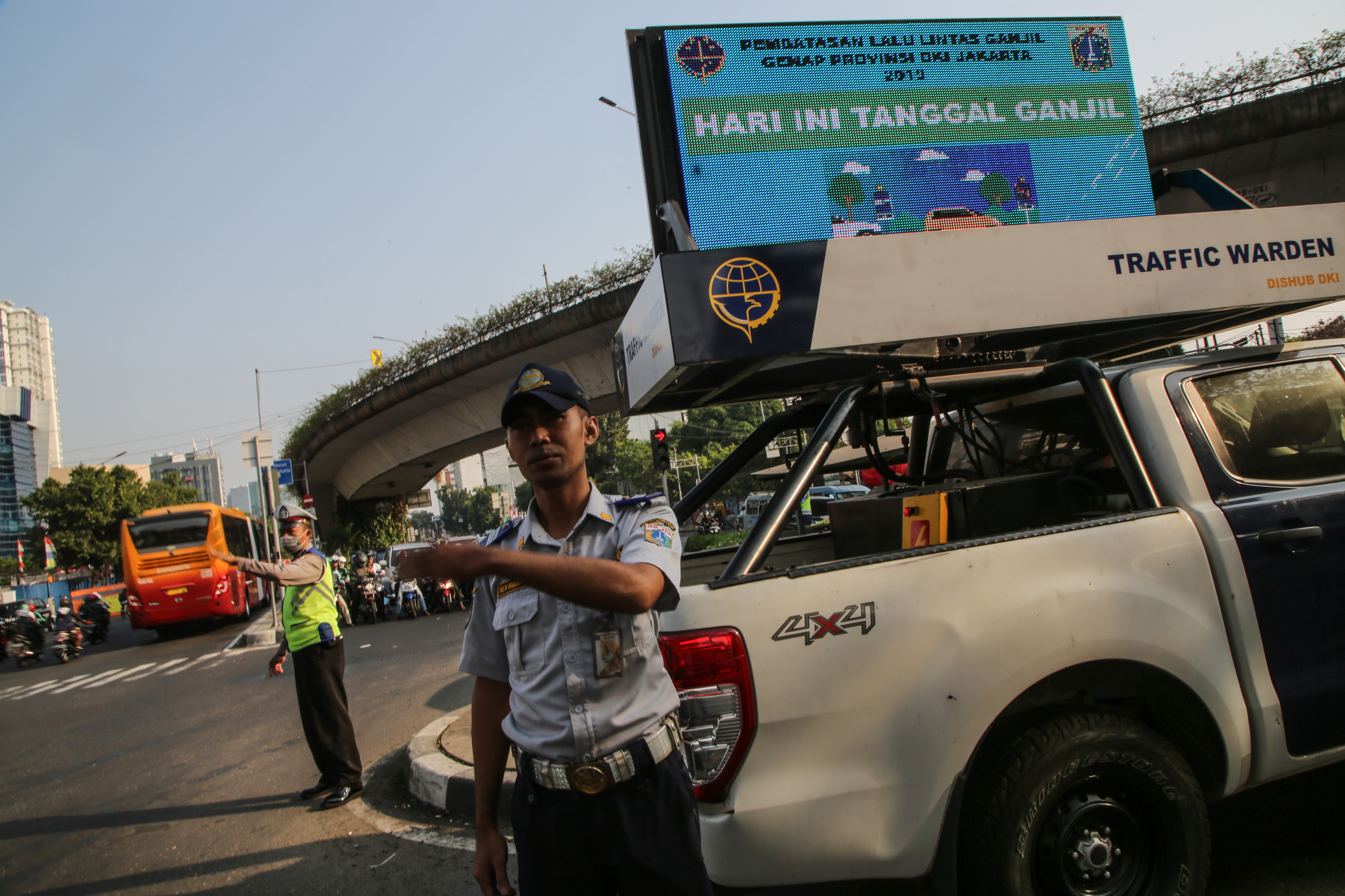 Petugas gabungan melakukan sosialisasi perluasan area ganjil genap di perempatan Matraman, Jakarta.