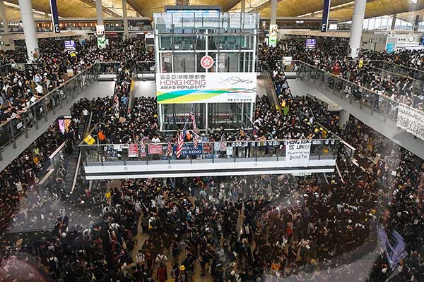 Ribuan pengunjuk rasa prodemokrasi menduduki Bandara Internasional Hong Kong.