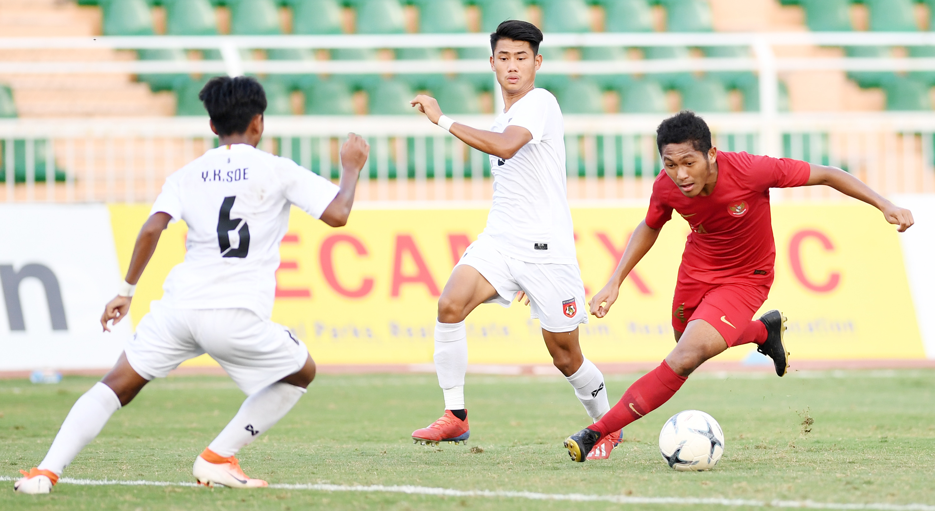 Pesepak bola Indonesia Muhammad Fajar Fatur Rachman (kanan) berusaha melewati dua pesepak bola Myanmar.