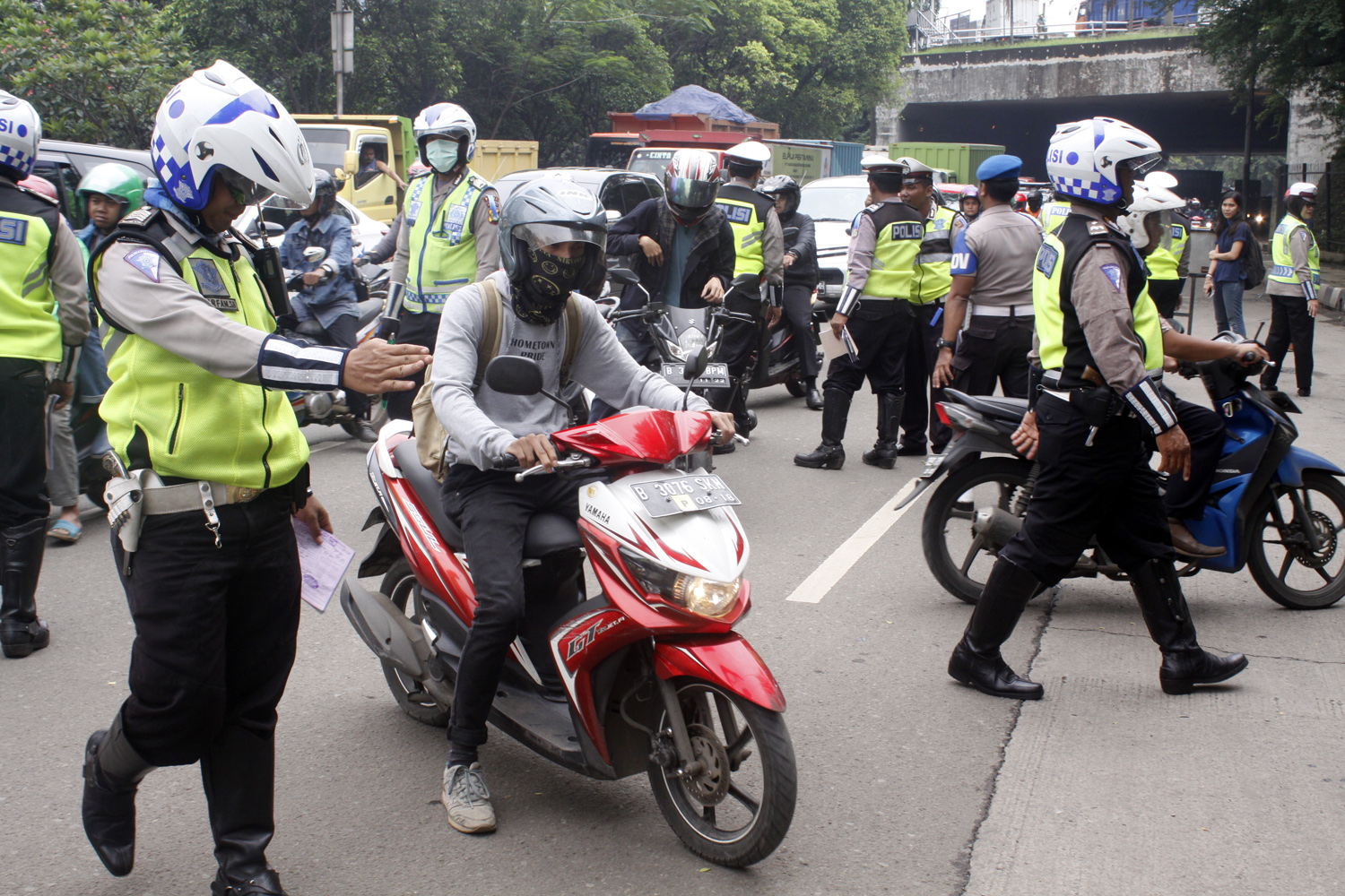 Polisi menghentikan kendaraan bermotor dan memeriksa kelengkapan surat berkendara di Jalan DI Panjaitan, Jakarta Timur
