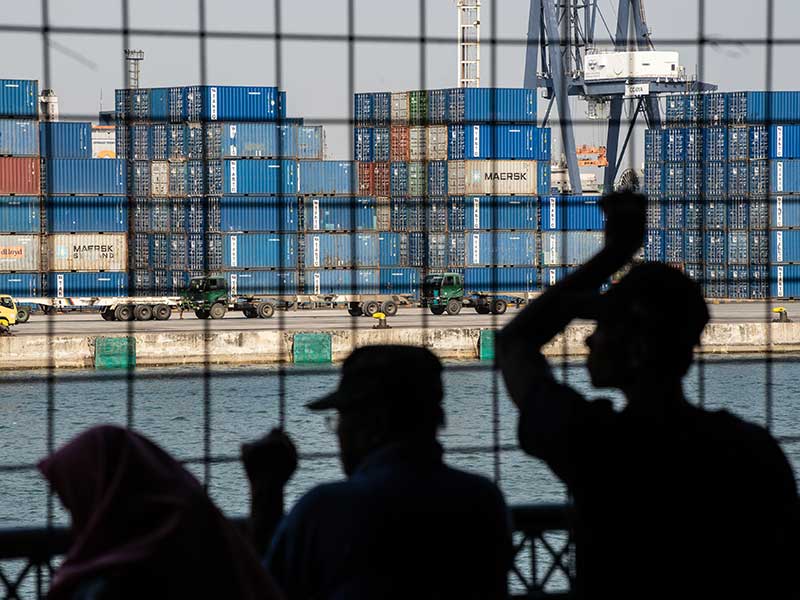 Warga melihat aktivitas bongkar muat peti kemas di Pelabuhan Tanjung Priok, Jakarta, Senin (15/7/2019).