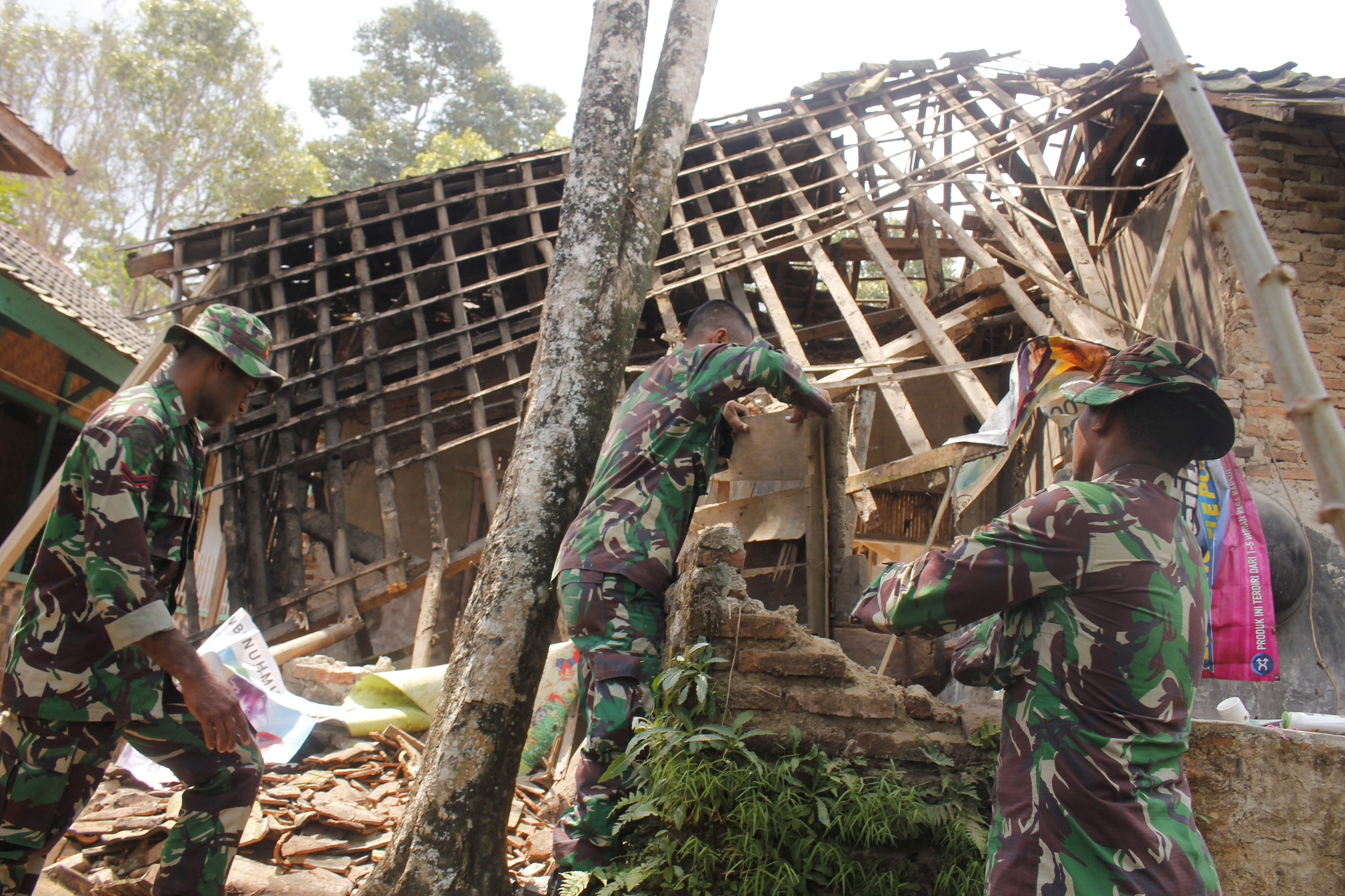  Sejumlah anggota TNI membongkar rumah yang rusak akibat gempa di Kampung Jaura, Pandeglang, Banten, Sabtu (3/8). 