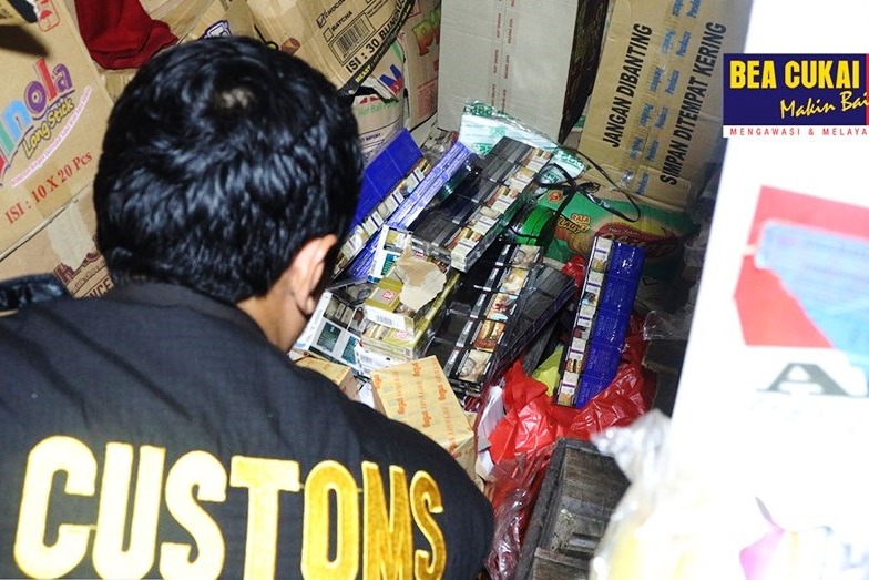 Petugas Bea Cukai sedang menggeledah penjual rokok eceran.
