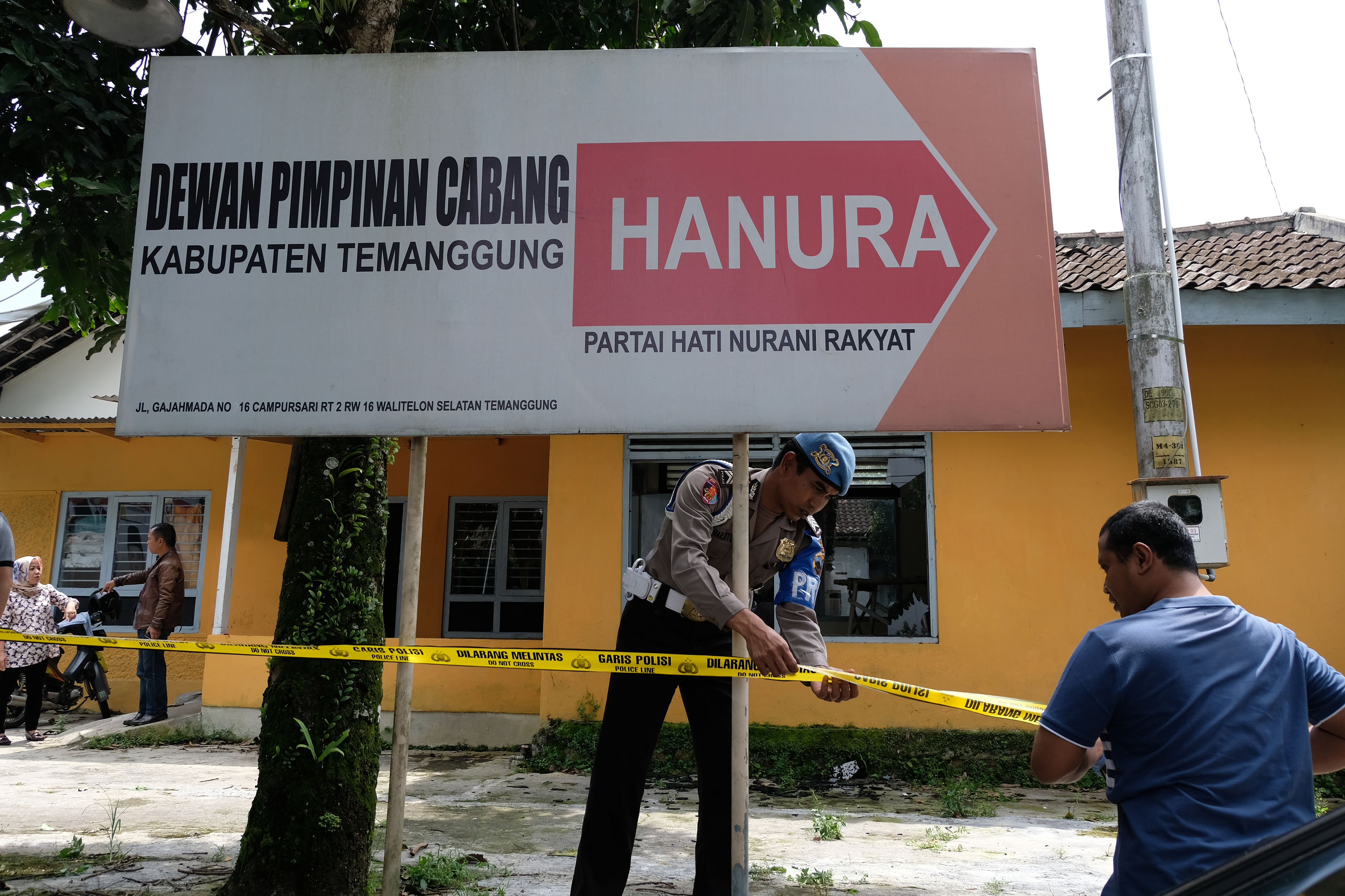 Polisi memasang garis polisi saat olah kejadian perkara perusakan kantor DPC Partai Hanura di Temanggung, Jawa Tengah.