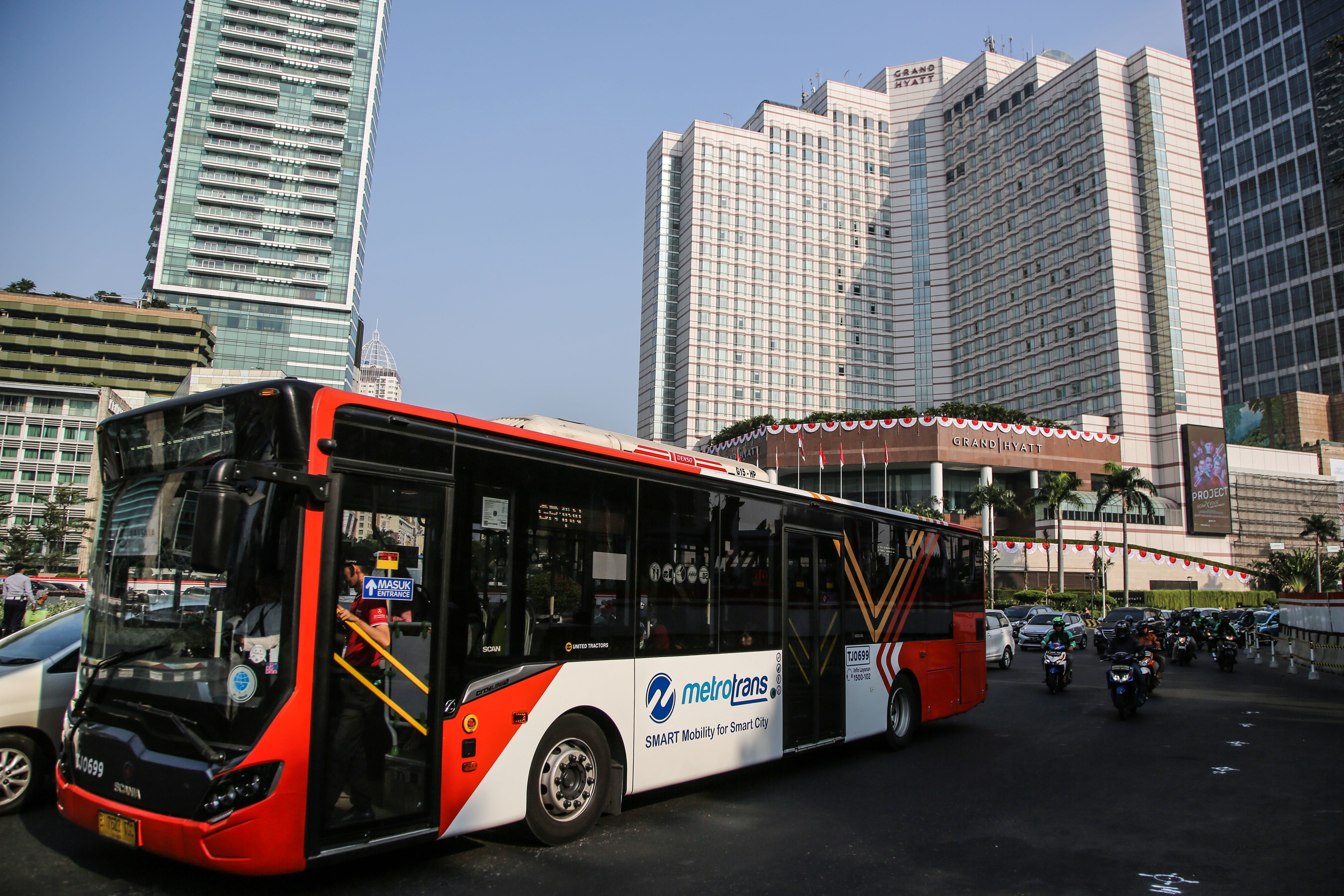 Warga menunggu bus di Halte Bus Transjakarta Harmoni, Jakarta Pusat