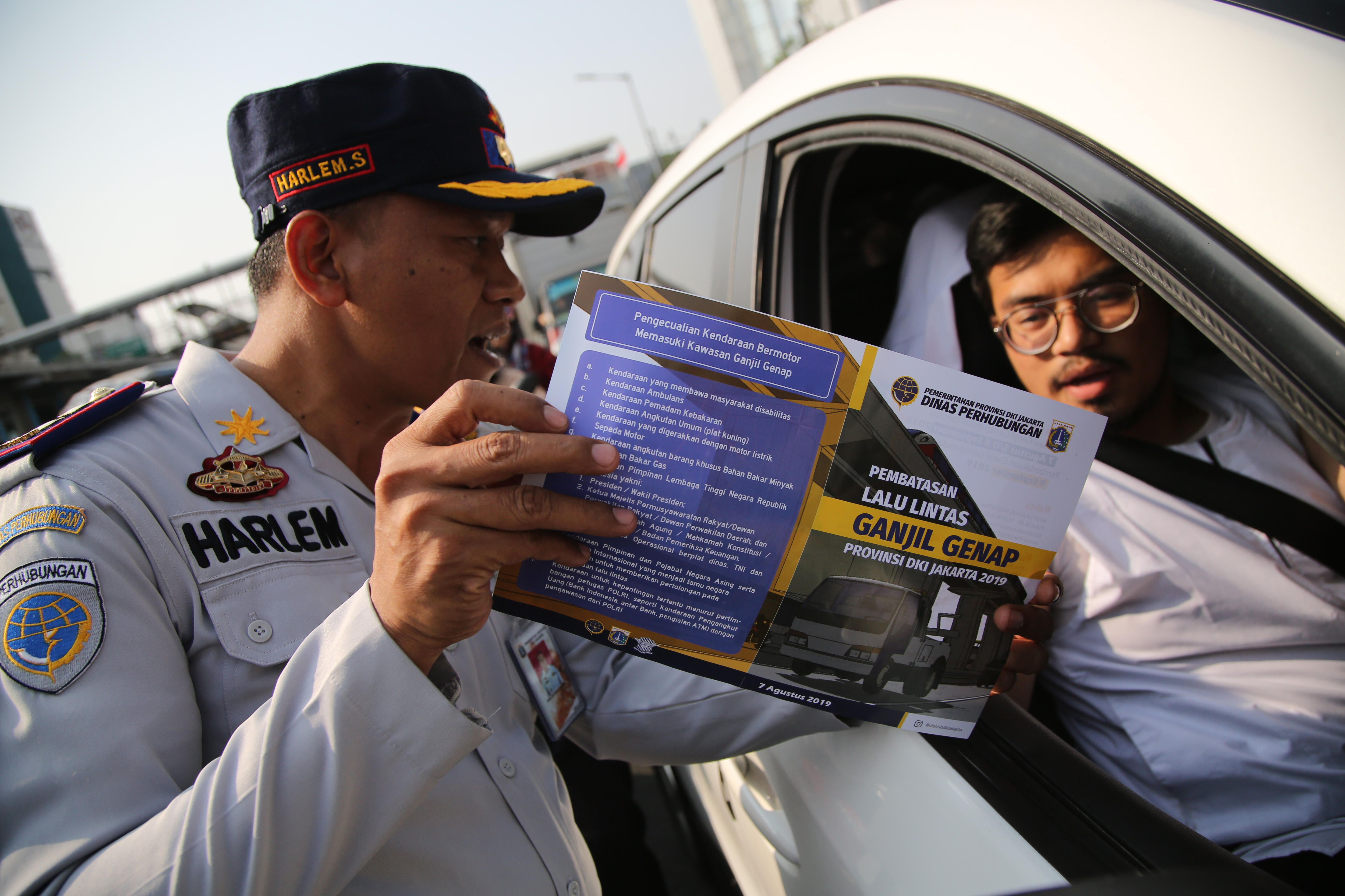 Petugas gabungan dari Polantas dan Dishub DKI Jakarta mengatur arus lalu lintas saat sosialisasi perluasan area ganjil genap, Senin (12/8).