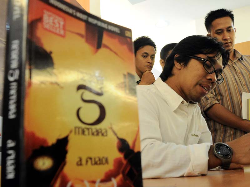 Penulis buku ' Negeri 5 Menara' Ahmad Fuadi, menandatangani buku untuk para penggemarnya.