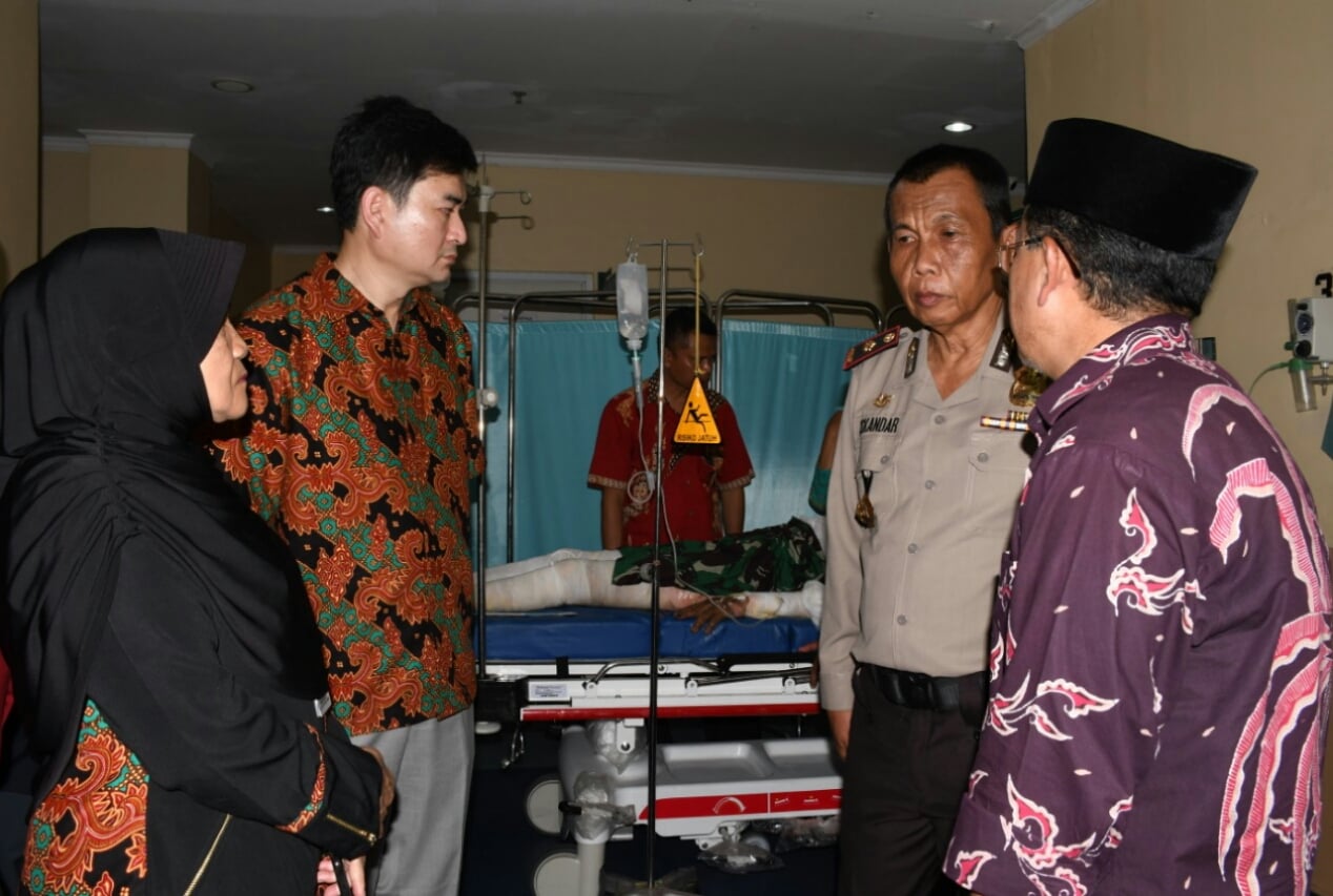 Pelaksana Tugas Bupati Cianjur, Jawa Barat, Herman Suherman (kanan), menjenguk anggota Polres Cianjur di RSUD Sayang Cianjur, Kamis (15/8).