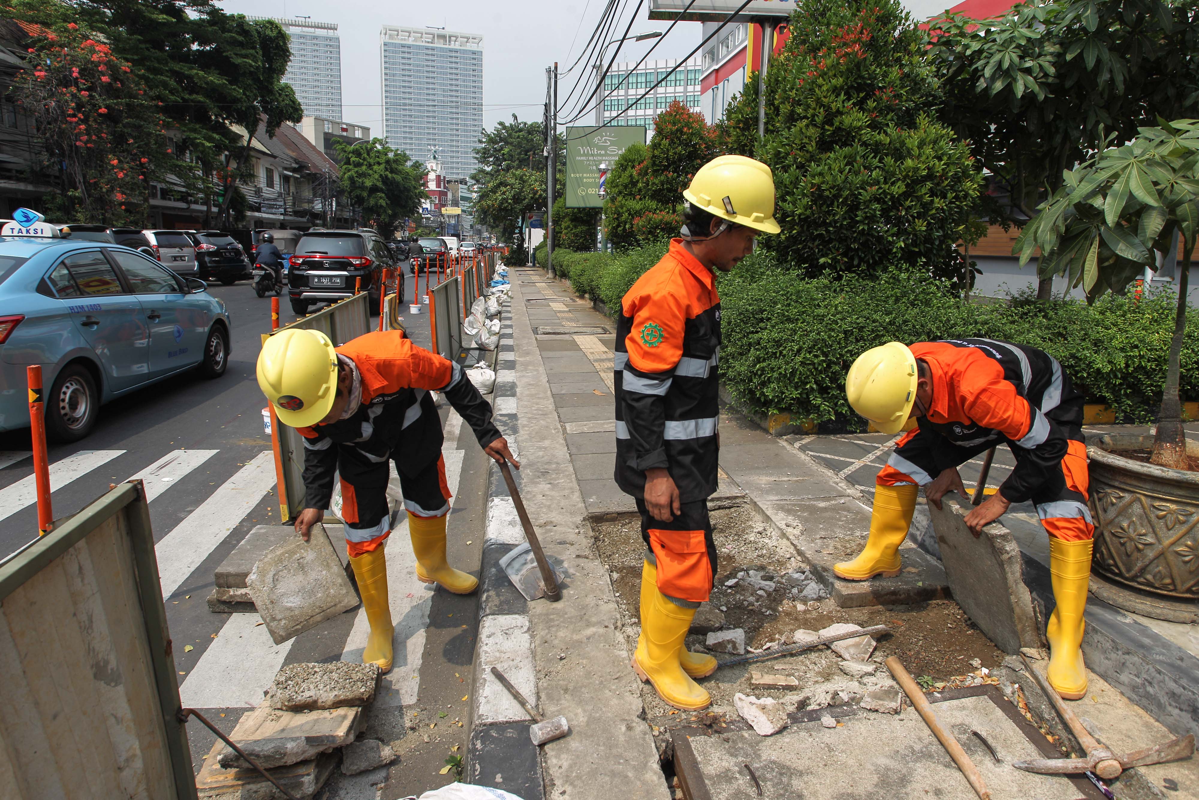 Pekerja membongkar trotoar yang terdapat di sepanjang Jalan Cikini Raya, Jakarta, Kamis (13/6).