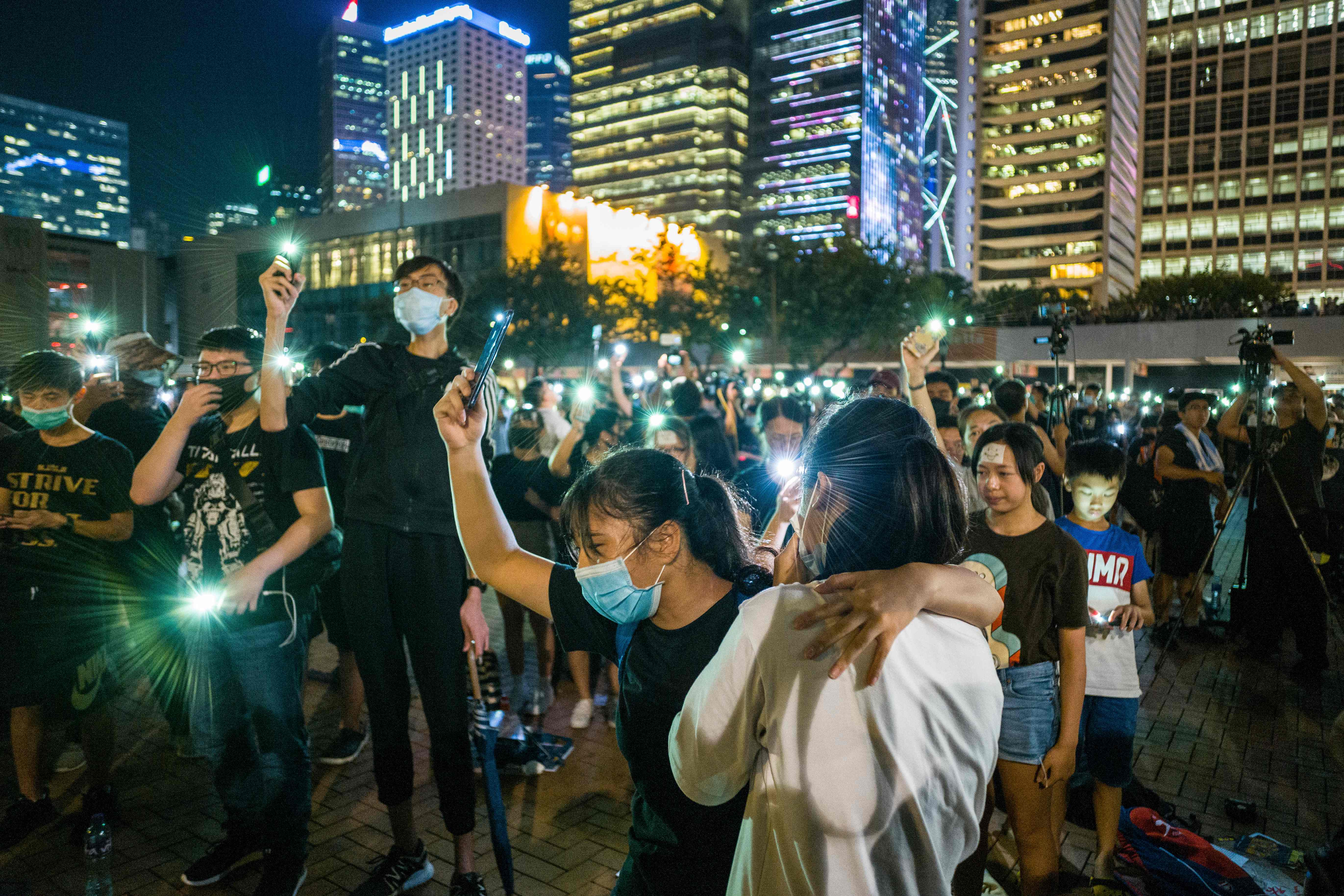 Para pelajar dan mahasiswa Hong Kong mengangkat ponsel mereka sembari menyanyikan 'Do You Hear the People Sing' saat melakukan aksi.