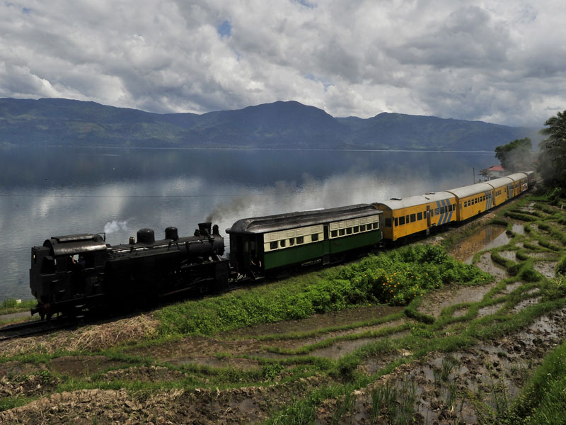 Lokomotif uap tua “Mak Itam”, melintas di tepi Danau Singkarak, Solok, Sumatera Barat.