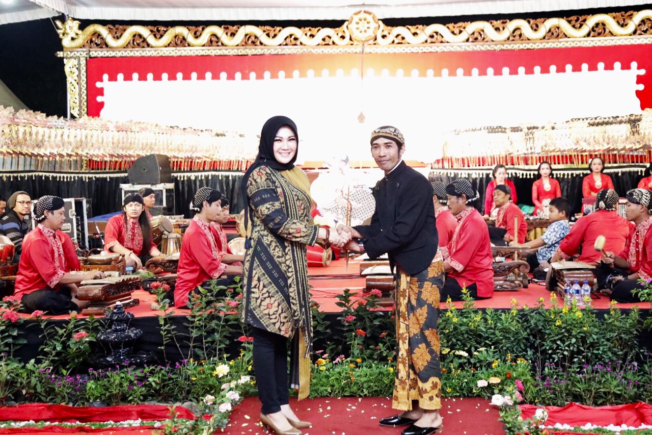 Bupati Sri Mulyani (kiri) menyerahkan tokoh Semar kepada dalang Ki Sigid Aryanto.