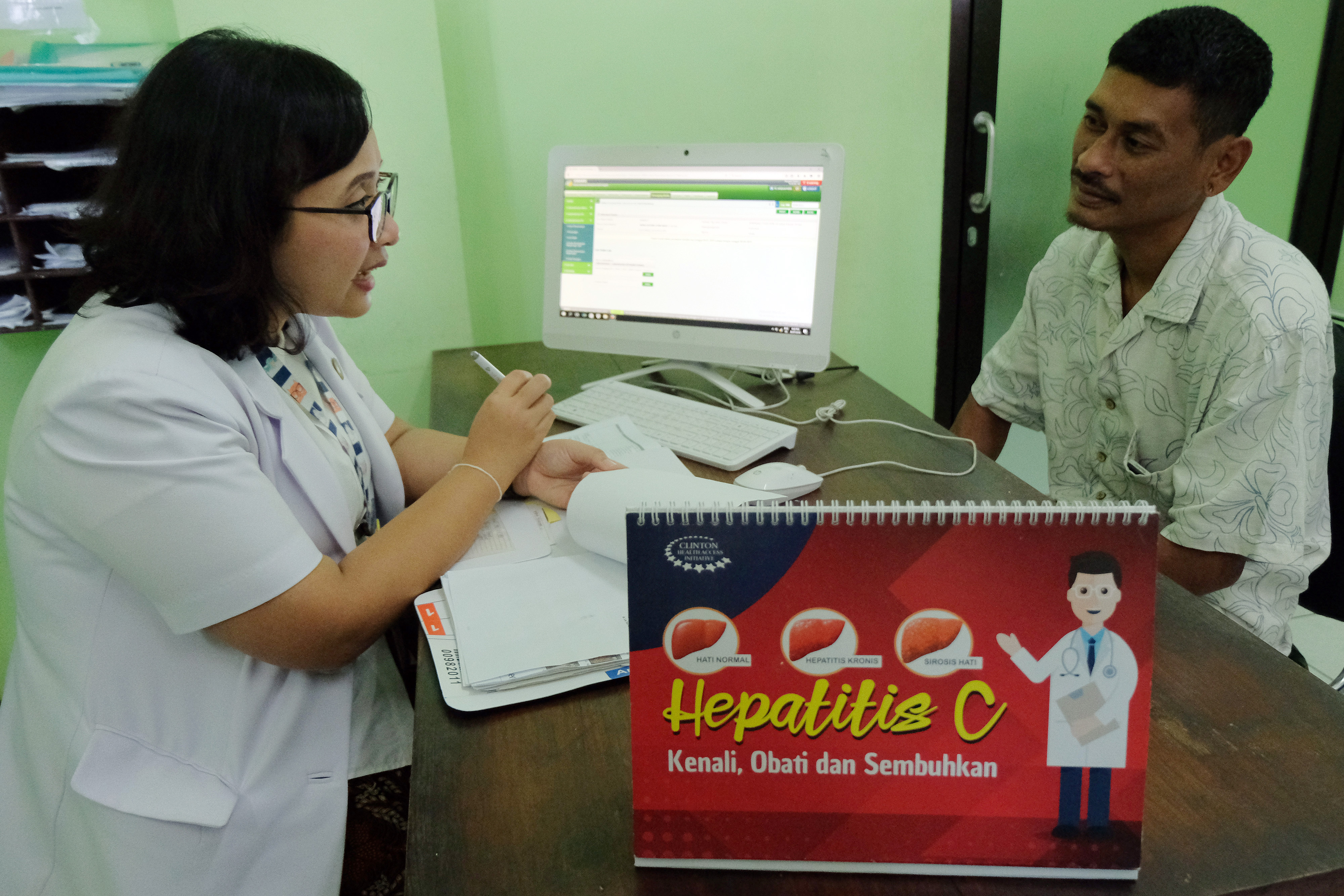 Dokter memberi penjelasan kepada warga saat digelarnya deteksi dini (screening) penyakit hepatitis.  