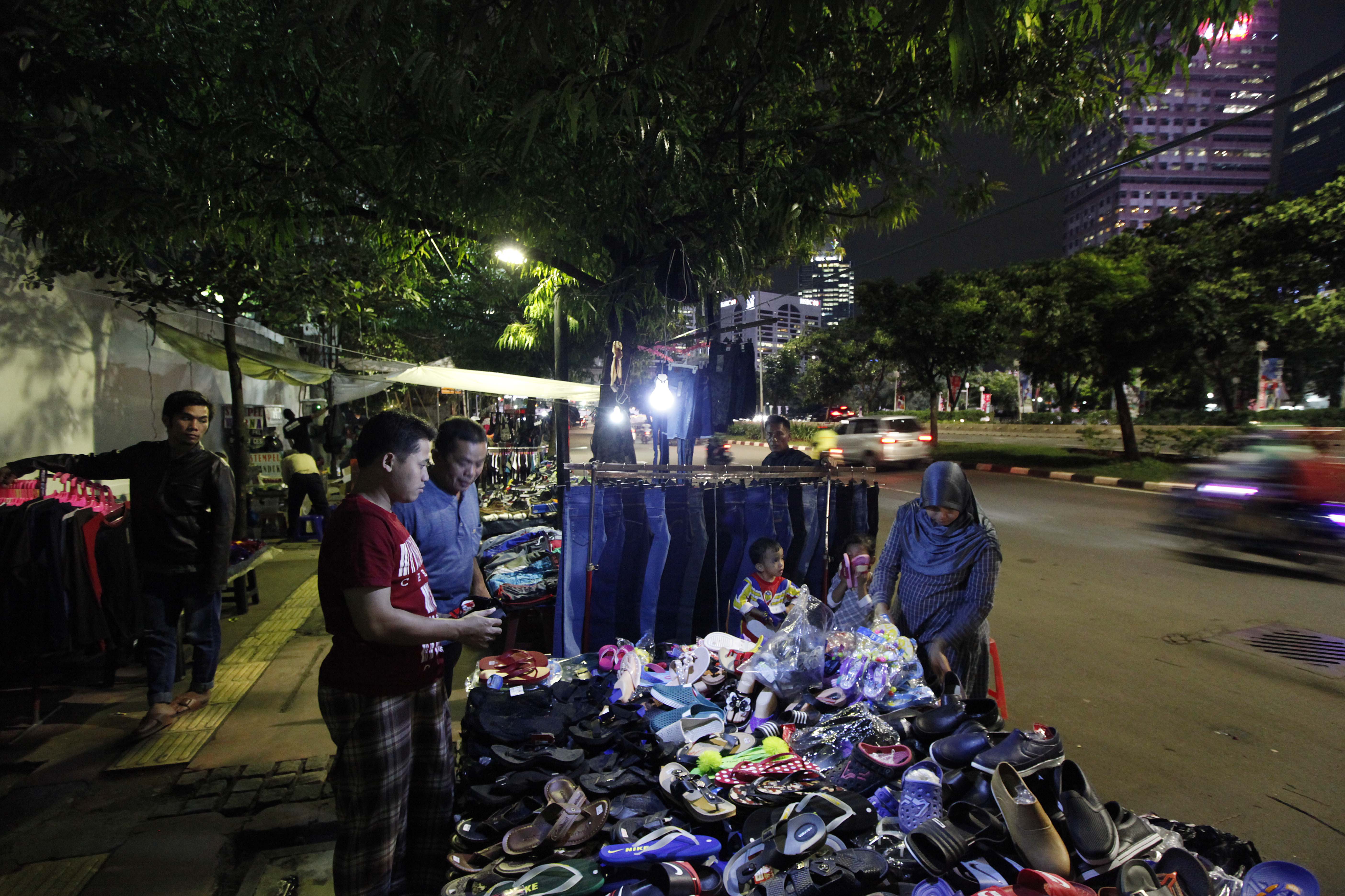 Pedagang kaki lima (pkl) berjualan berbagai produk seperti sepatu, sandal, baju di Jalan Sudirman, kawasan Bendungan Hilir, Jakarta Pusat.
