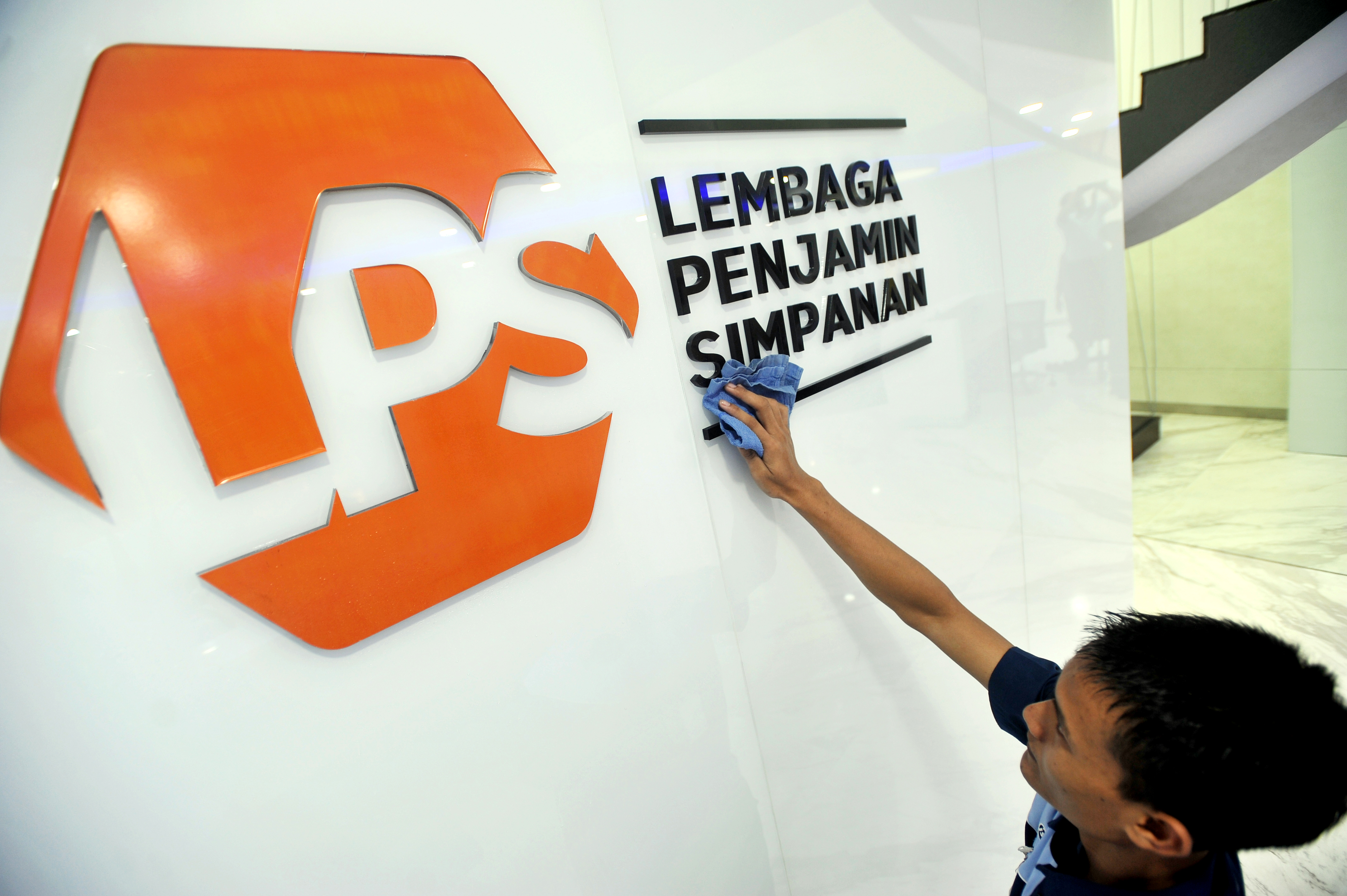 Karyawan membersihkan logo baru Lembaga Penjamin Simpanan (LPS) di Jakarta, beberapa waktu lalu.