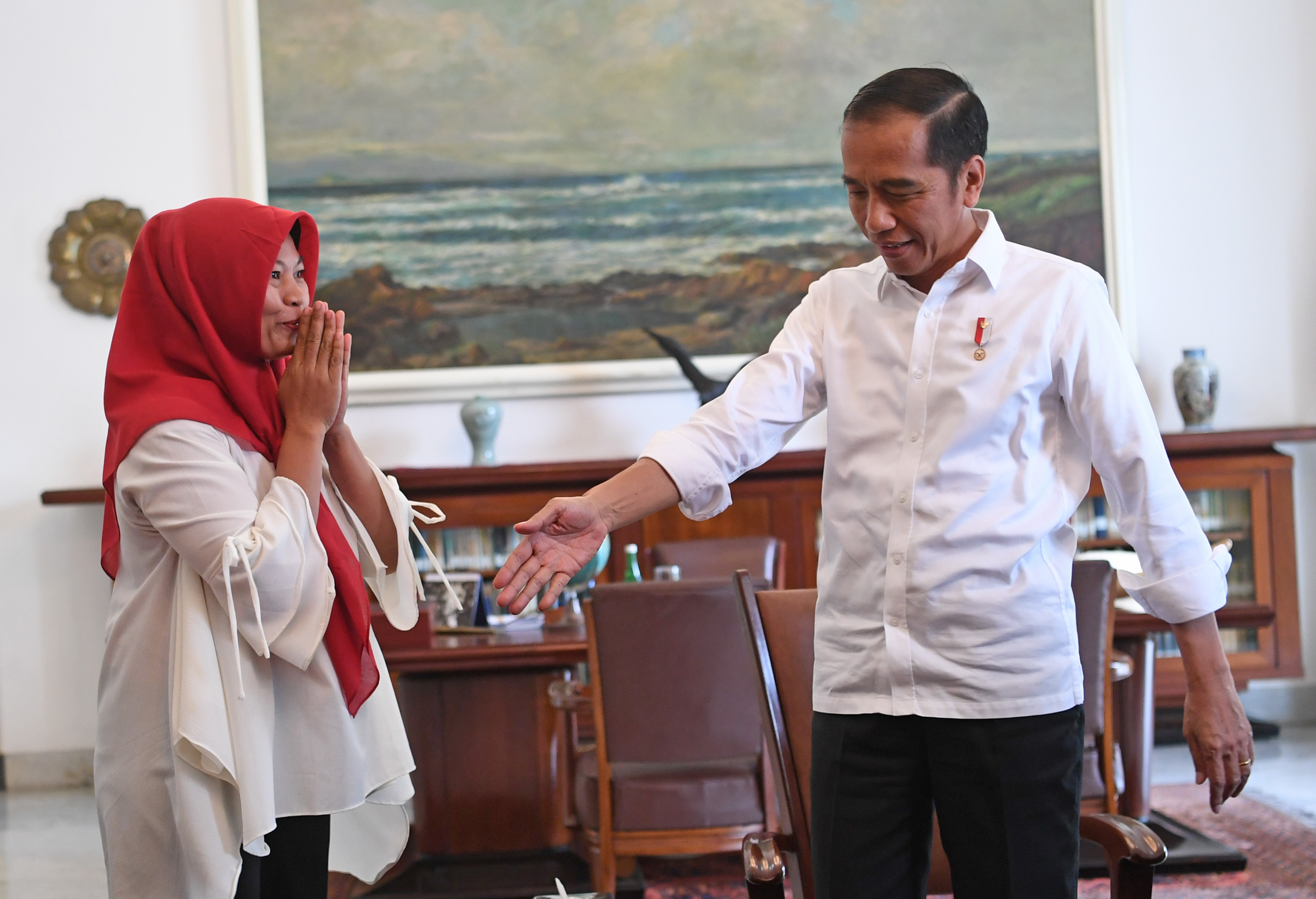 Presiden Joko Widodo (kanan) menerima terpidana kasus pelanggaran Undang-Undang Informasi dan Transaksi Elektronik (ITE) Baiq Nuril Maknun.