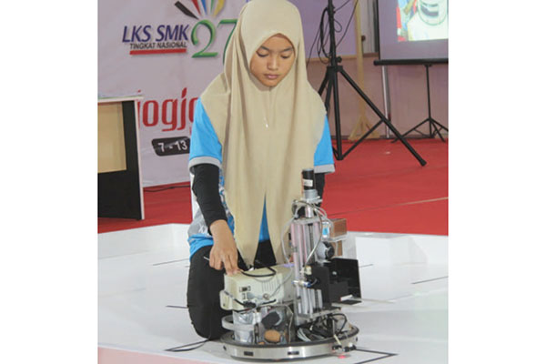 Siswi SMK sedang melakukan pengoperasian mesin