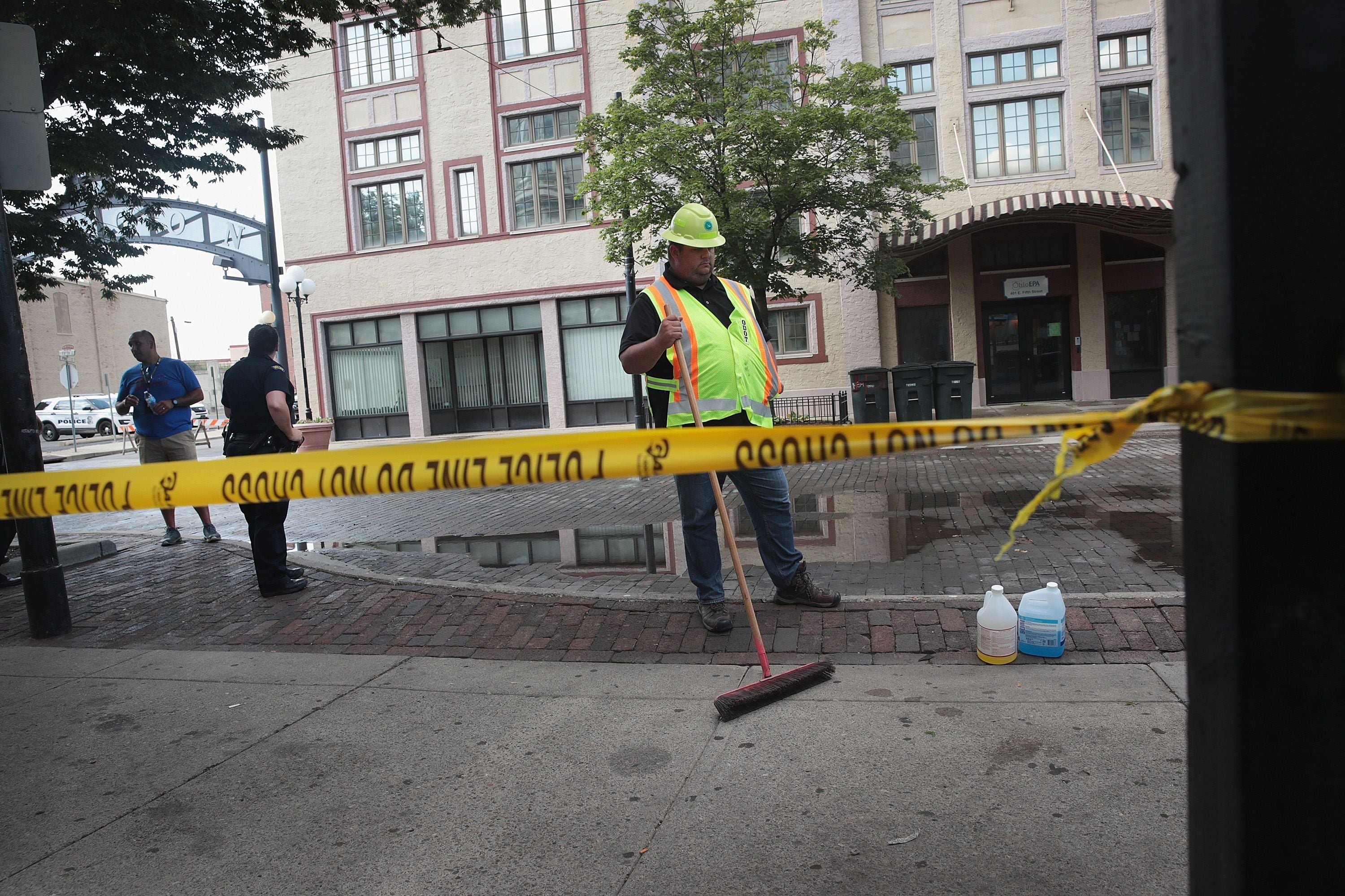 Seorang petugas membersihkan lokasi penembakan massal di Dayton sebelum lokasi tersebut dibuka kembali untuk publik.