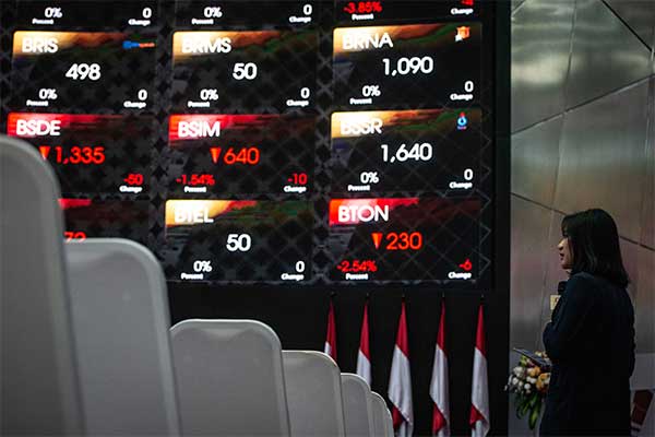 Karyawan beraktivitas di dekat grafik pergerakan saham di gedung Bursa Efek Indonesia, Jakarta, Jumat (2/8/2019). 