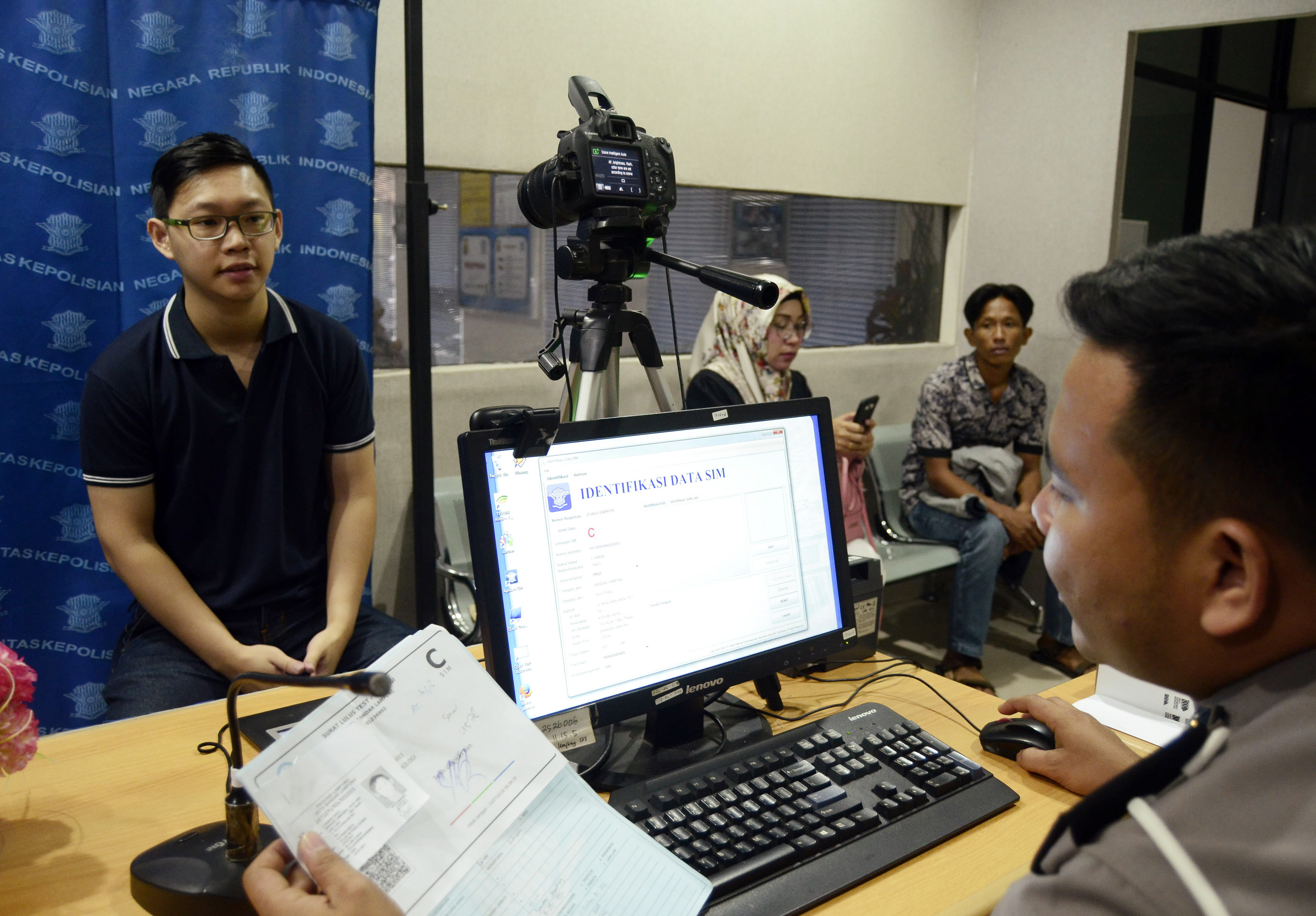 Petugas melakukan perekeman data pemohon Surat Izin Mengemudi (SIM) di ruang pembuatan SIM Satlantas Polresta Bandar Lampung, Lampung.