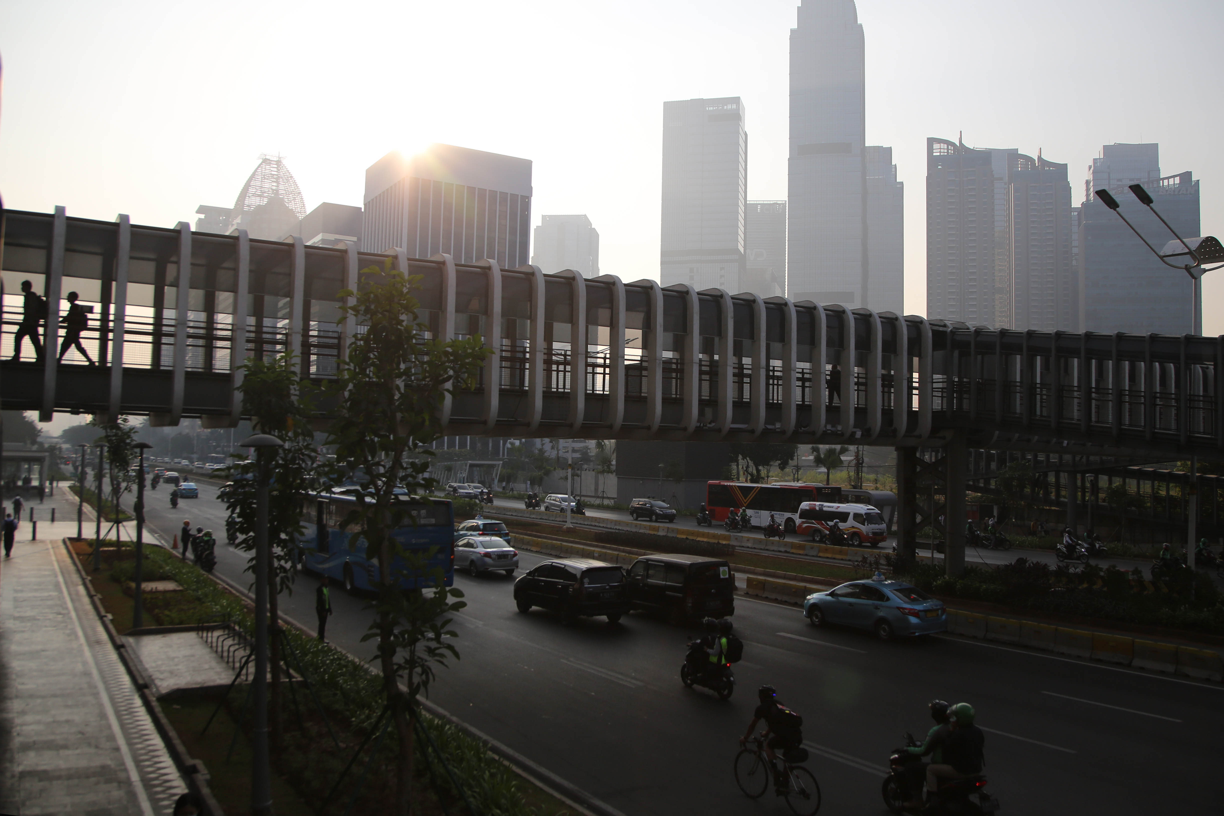 Suasana Jalan Sudirman dengan latar belakang gedung bertingkat.