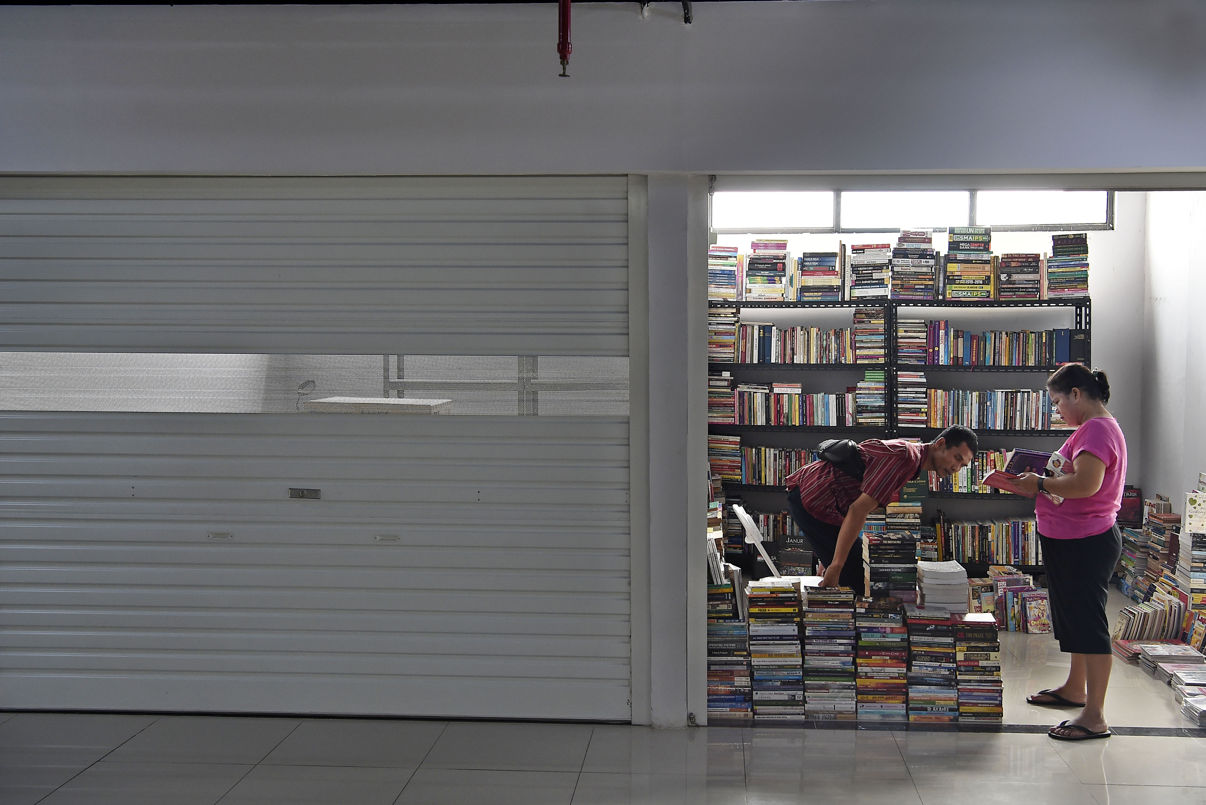 Pedagang melayani pembeli buku dagangannya di Pasar Buku Kenari, Salemba, Jakarta Pusat, Senin (29/7/2019)