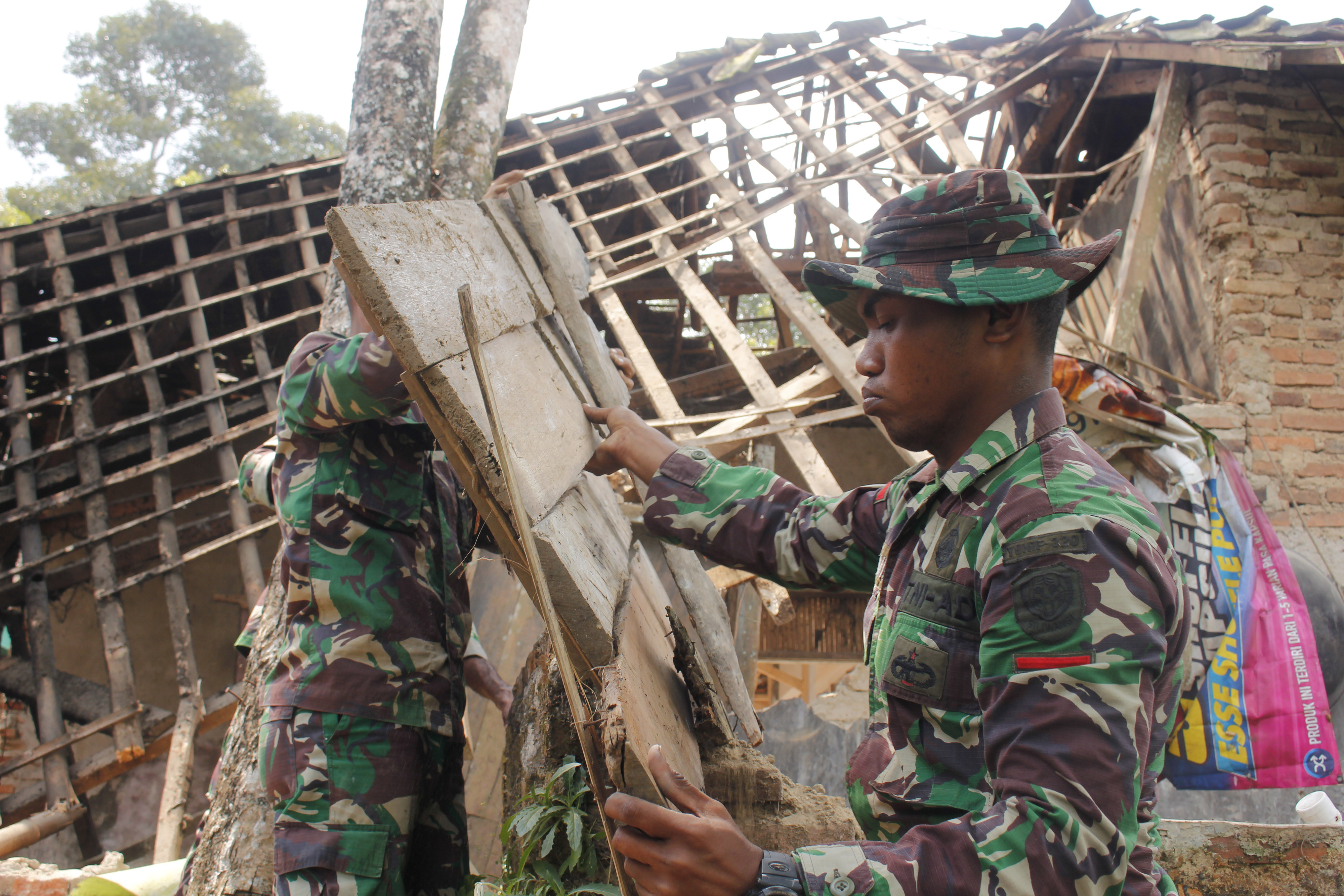 Sejumlah anggota TNI membongkar rumah yang rusak akibat gempa di Kampung Jaura, Pandeglang, Banten, hari ini.