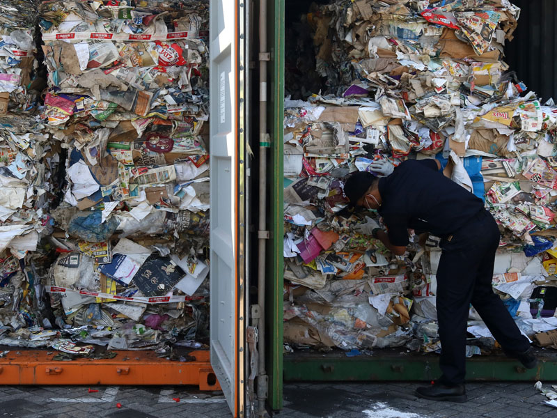 : Petugas menunjukkan kertas bekas (waste paper) impor yang dikirim dari Australia di lapangan penumpukkan kontainer.