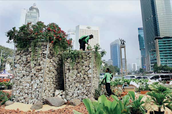 Petugas dari Dinas Kehutanan Pemprov DKI Jakarta memasang tanaman bugenvil di atas intalasi batu gabion di kawasan Bundaran Hotel Indonesia,