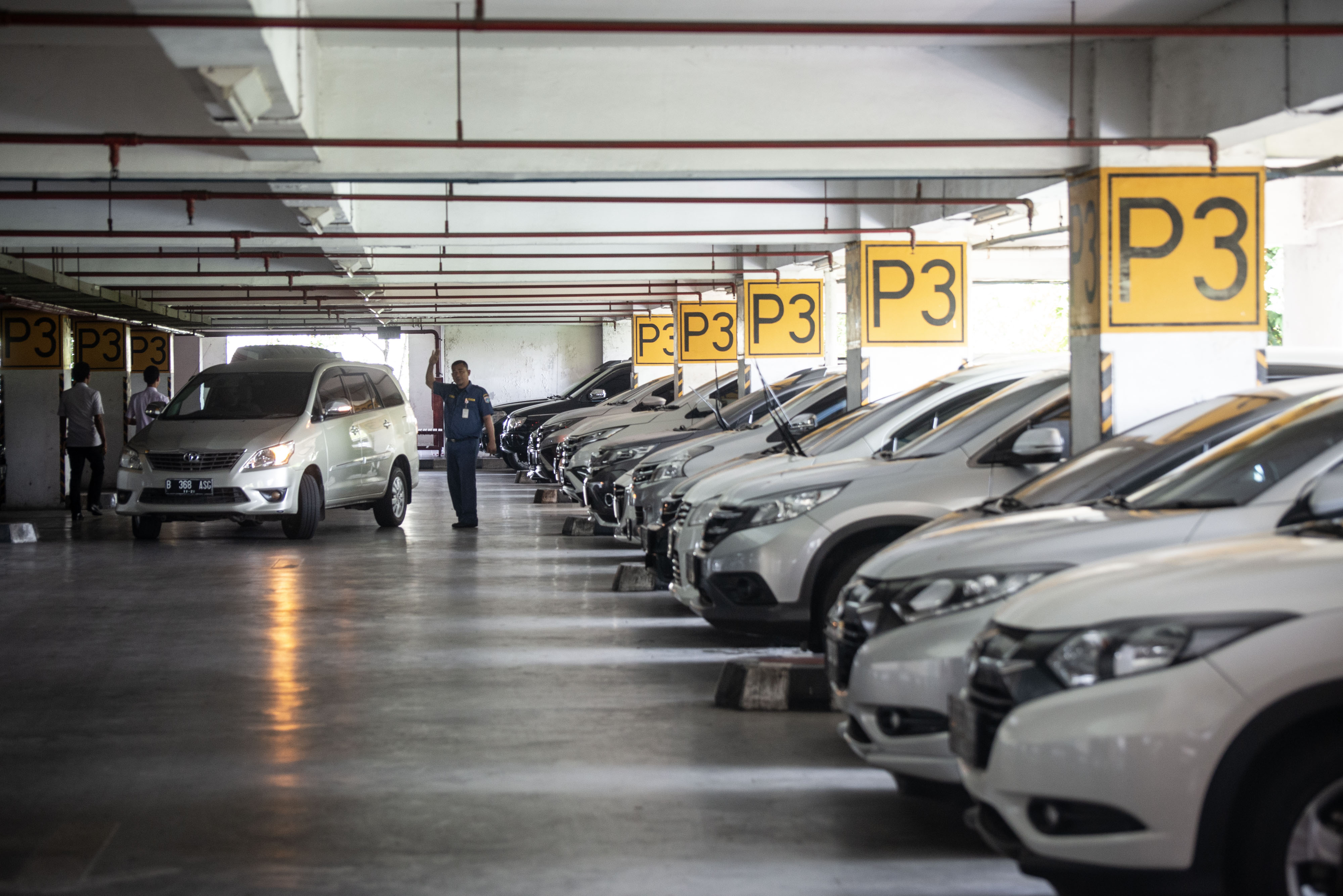 Petugas mengarahkan kendaraan di tempat parkir Kantor Wali Kota Jakarta Utara, Jakarta.