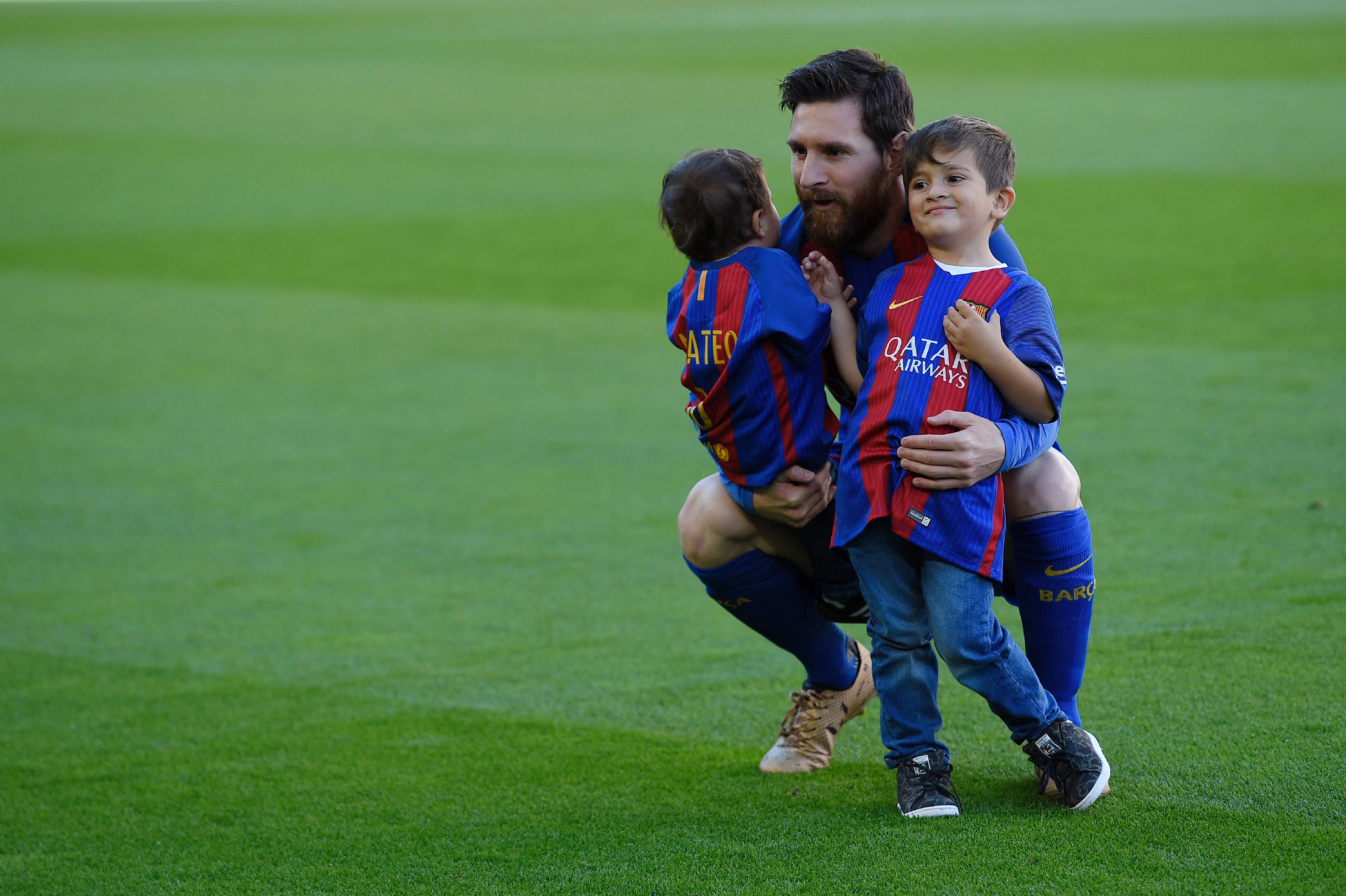 Lionel Messi bersama kedua anaknya, Mateo (kiri) dan Thiago.