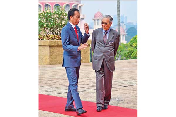 Presiden Joko Widodo berbincang dengan Perdana Menteri Malaysia Mahathir Mohamad (kanan)