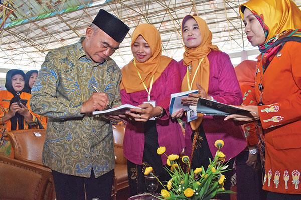 Menteri Pendidikan dan Kebudayaan Muhadjir Eff endy (kiri) melayani permintaan tanda tangan pada buku yang disodorkan guru
