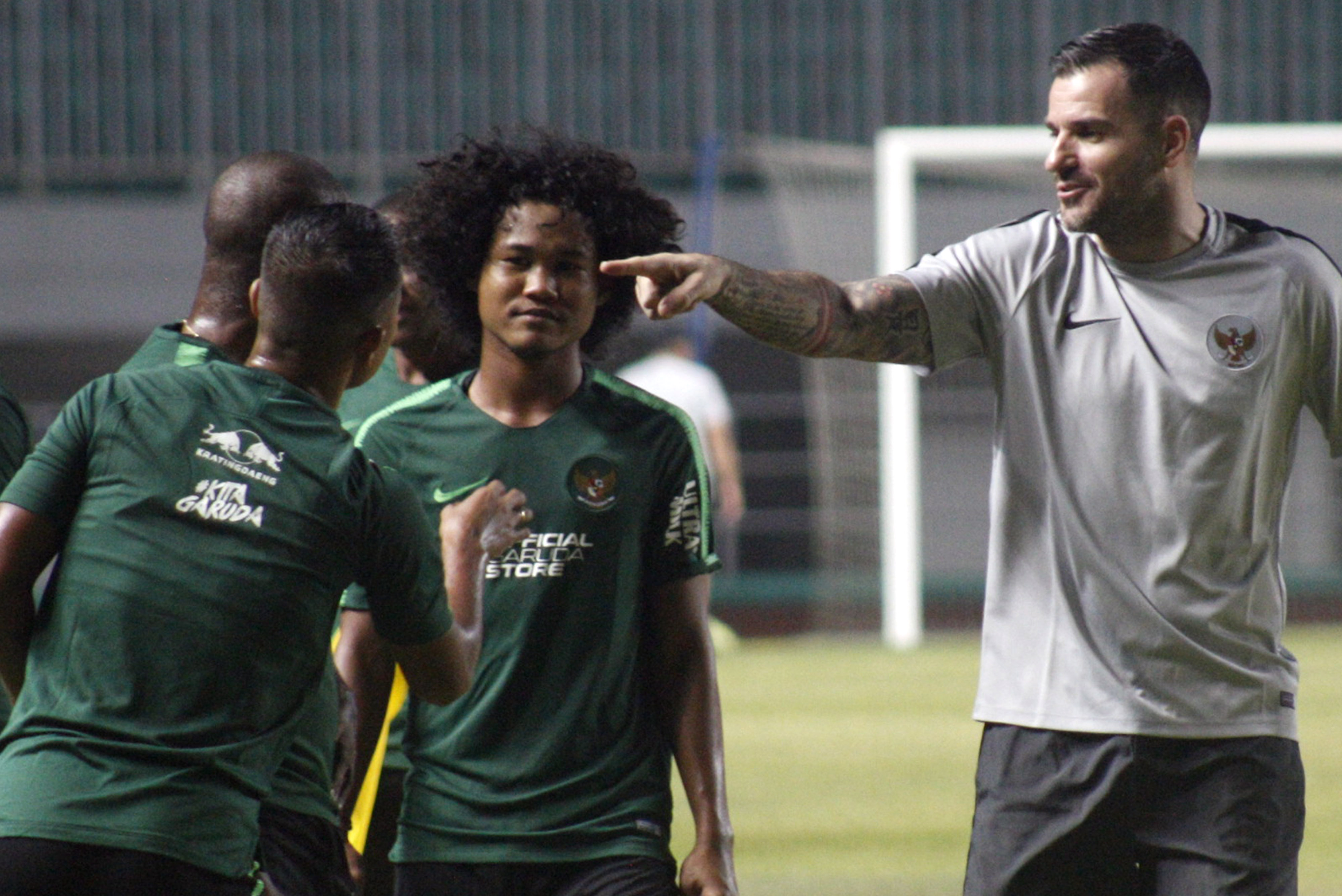 Pesepak bola Bagus Kahfie (kedua kanan) diberikan pengarahan oleh pelatih timnas senior Simon McMenemy (kanan).