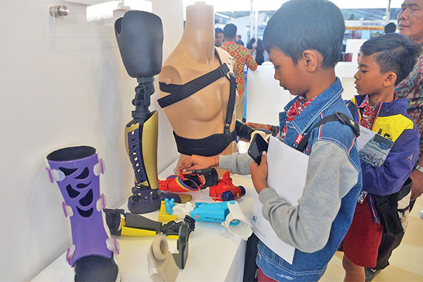 Dua siswa melihat tangan dan kaki palsu untuk penyandang disabilitas pada Ritech Expo 2019