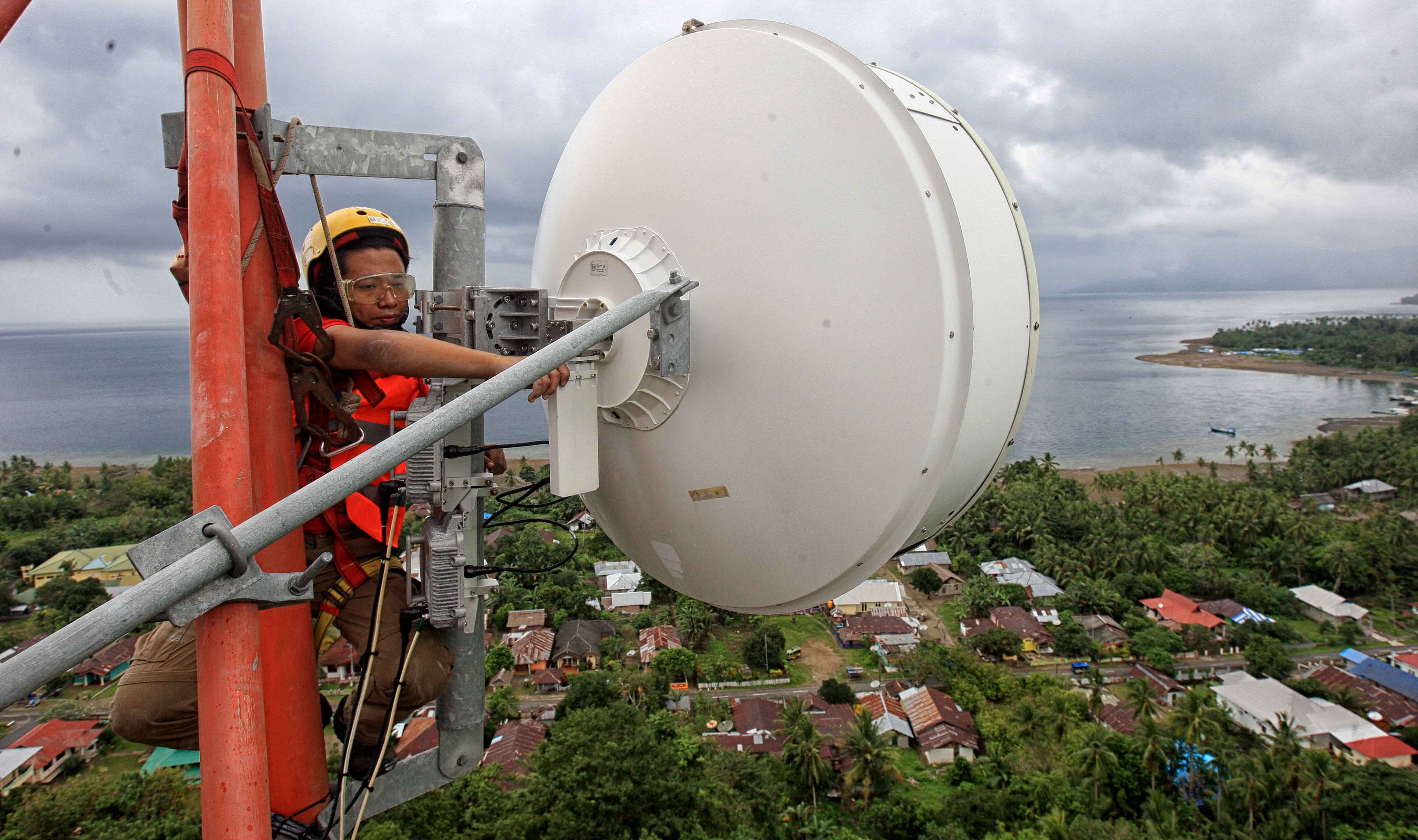  Seorang teknisi melakukan perawatan Base Transceiver Station (BTS) di Desa Hila, Ambon, Maluku.