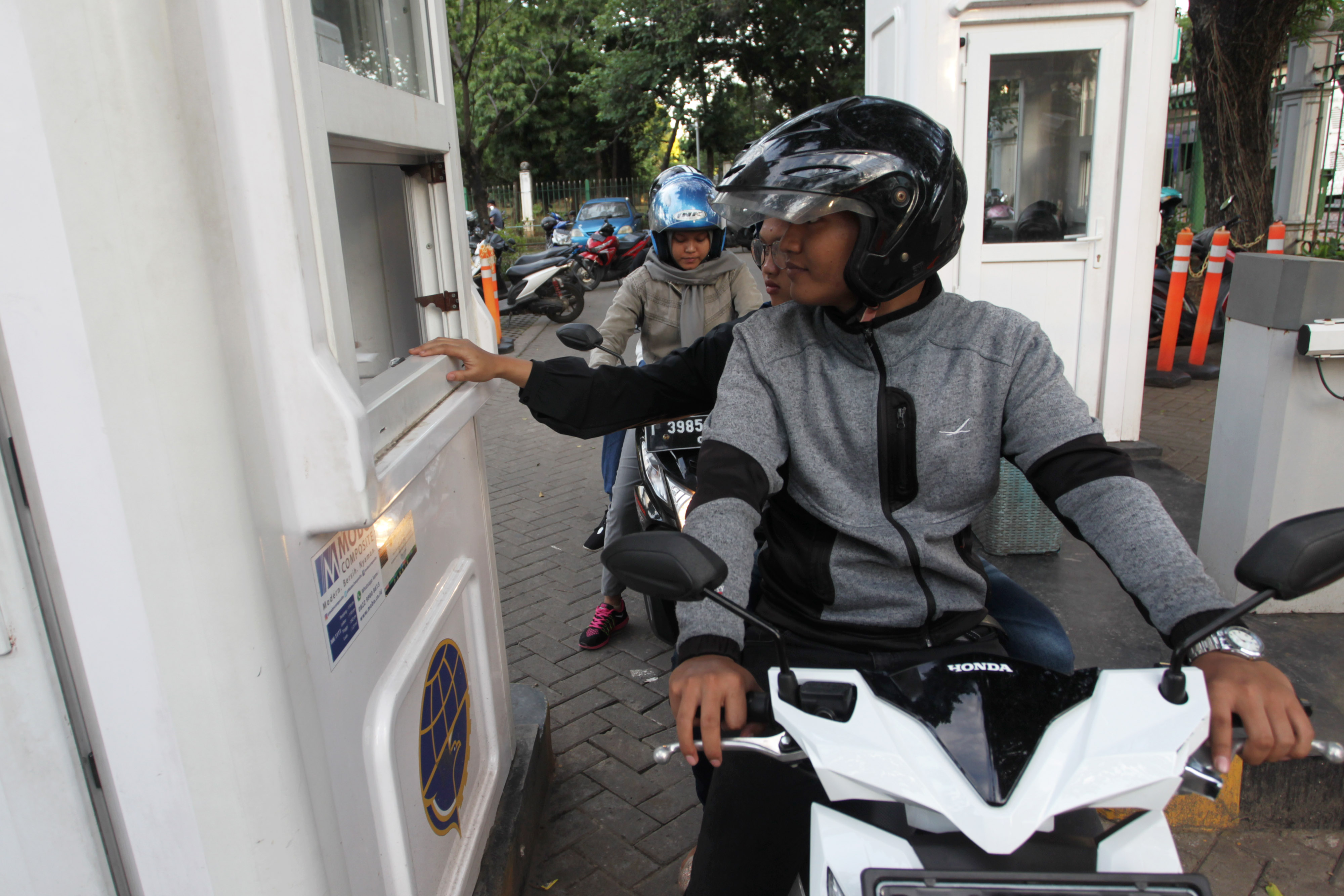 Pengendara membayar uang parkir di loket tempat parkir IRTI, Monas, Jakarta.