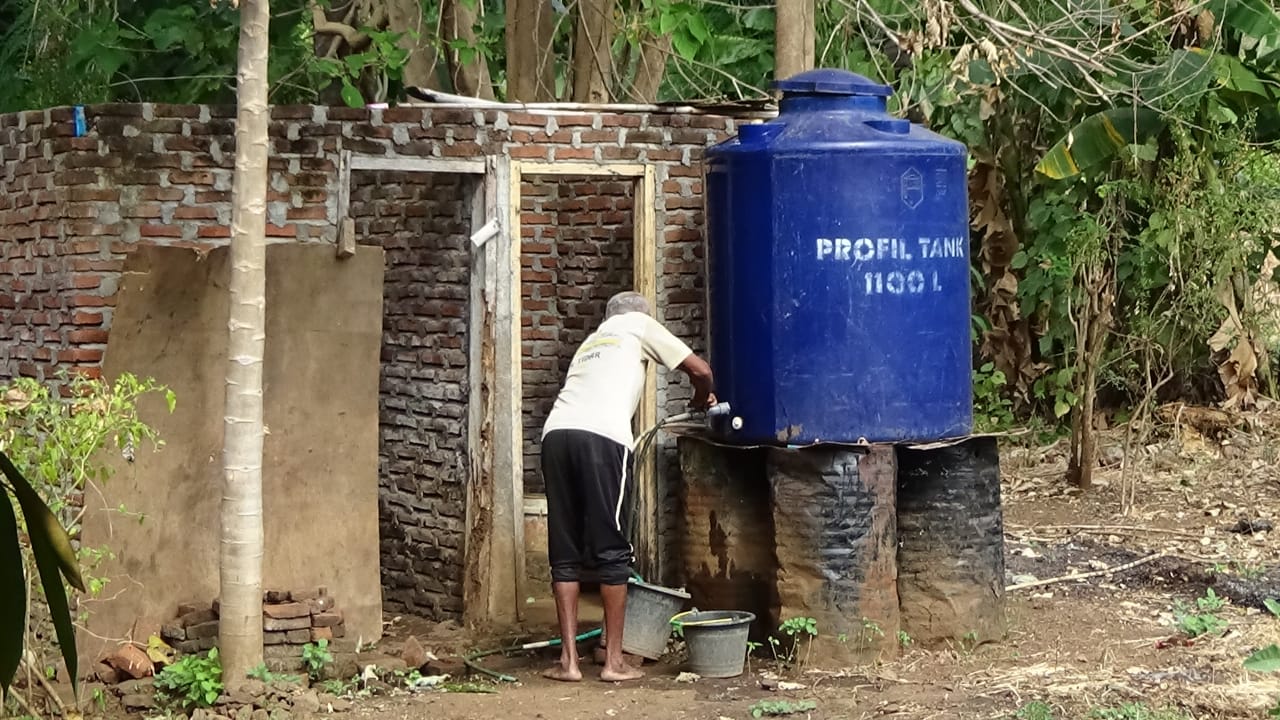 Seorang warga berusaha mendapatkan air dari tempat penampungan di Flotim.