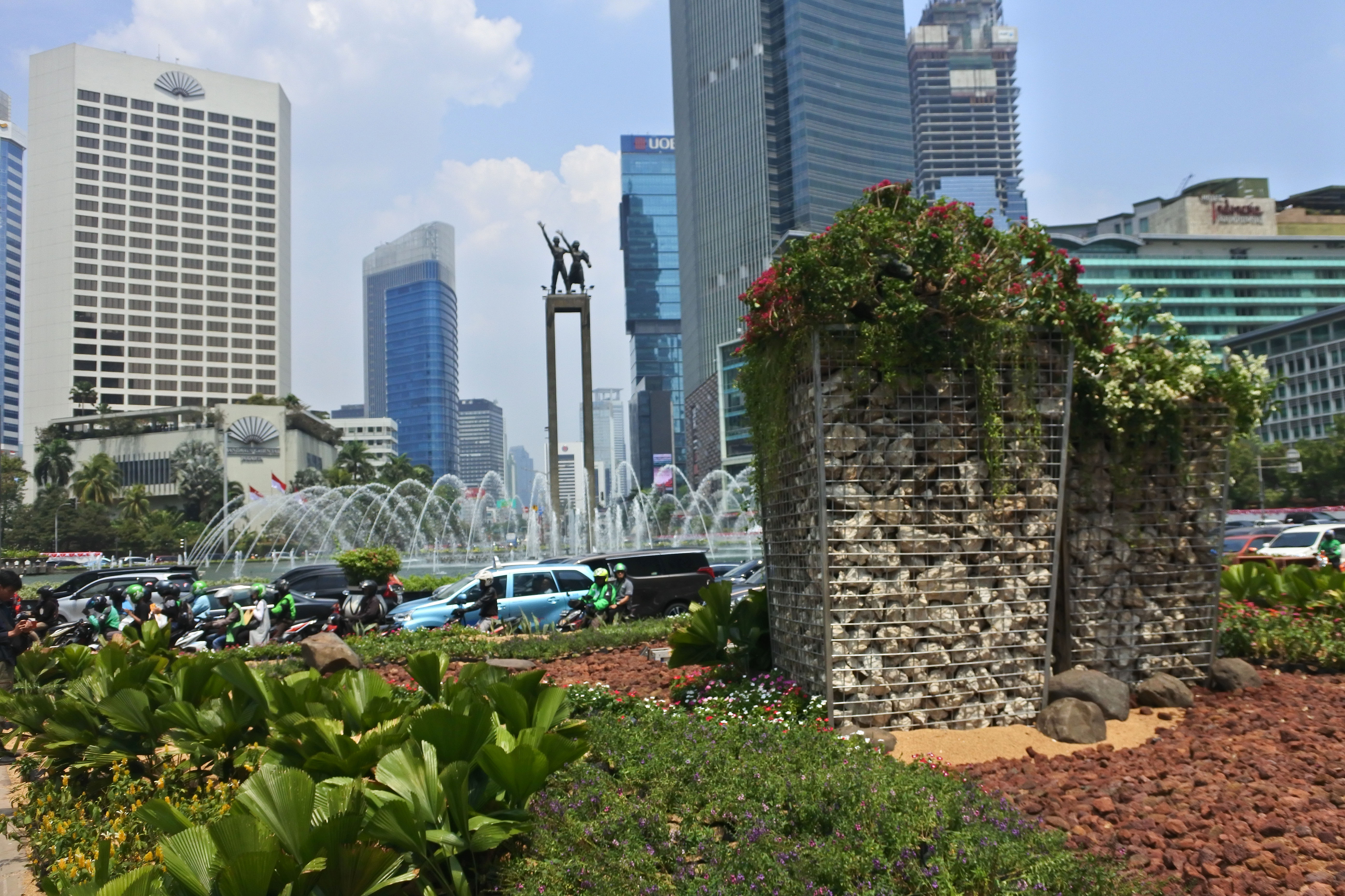 Instalasi gabion dengan latar belakang patung Selamat Datang di Bundaran Hotel Indonesia.