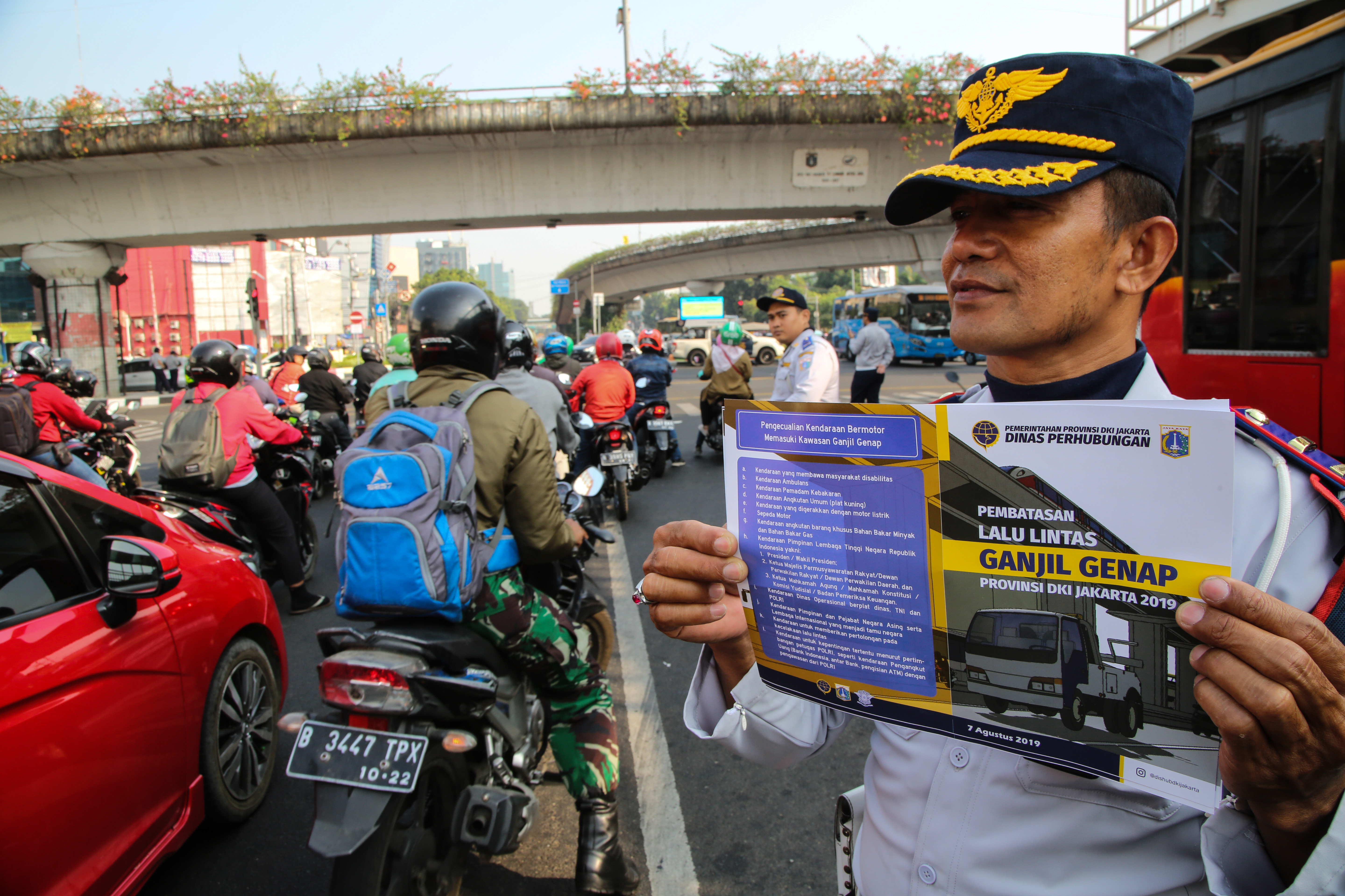 Petugas gabungan melakukan sosialisasi perluasan area ganjil genap di perempatan Matraman, Jakarta.