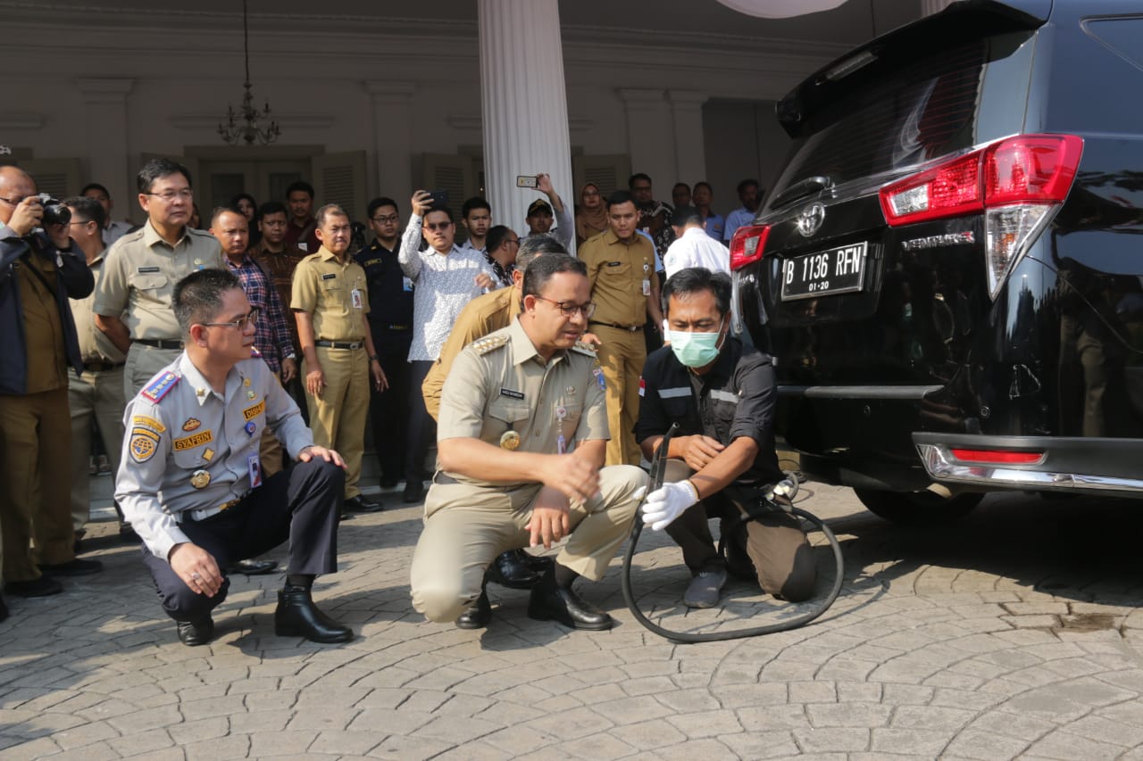 Gubernur DKI Jakarta Anies Baswedan (tengah) meninjau proses uji emisi pada kendaraan dinas operasional maupun transportasi umum JakLingko.