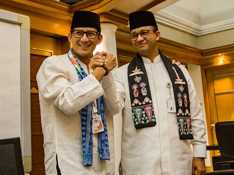 Gubernur DKI Jakarta Anies Baswedan (kanan) berjabat tangan dengan Sandiaga Uno (kiri) usai pengunduran diri Sandiaga sebagai Wagub DKI