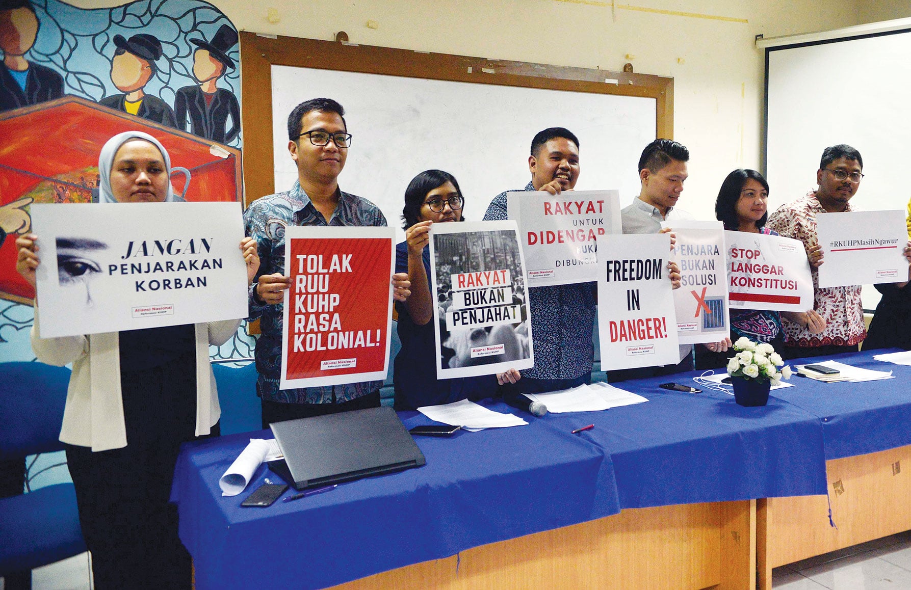 Para aktivis yang tergabung dalam Aliansi Nasional Reformasi KUHP memegang poster penolakan rencana pengesahan RKUHP