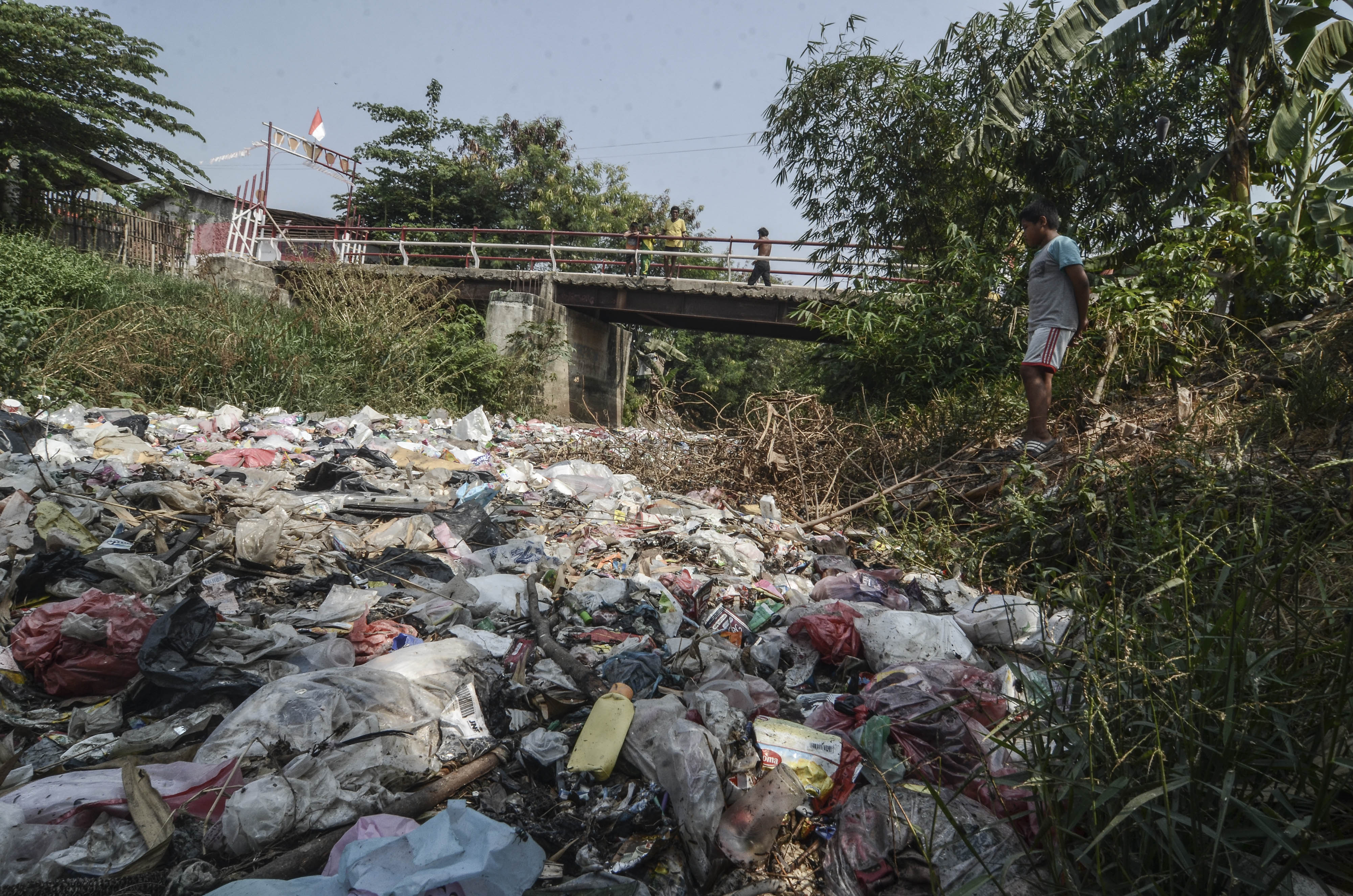 Warga mengamati Kali Jambe yang dipenuhi sampah di Desa Mangun Jaya, Tambun, Kabupaten Bekasi.